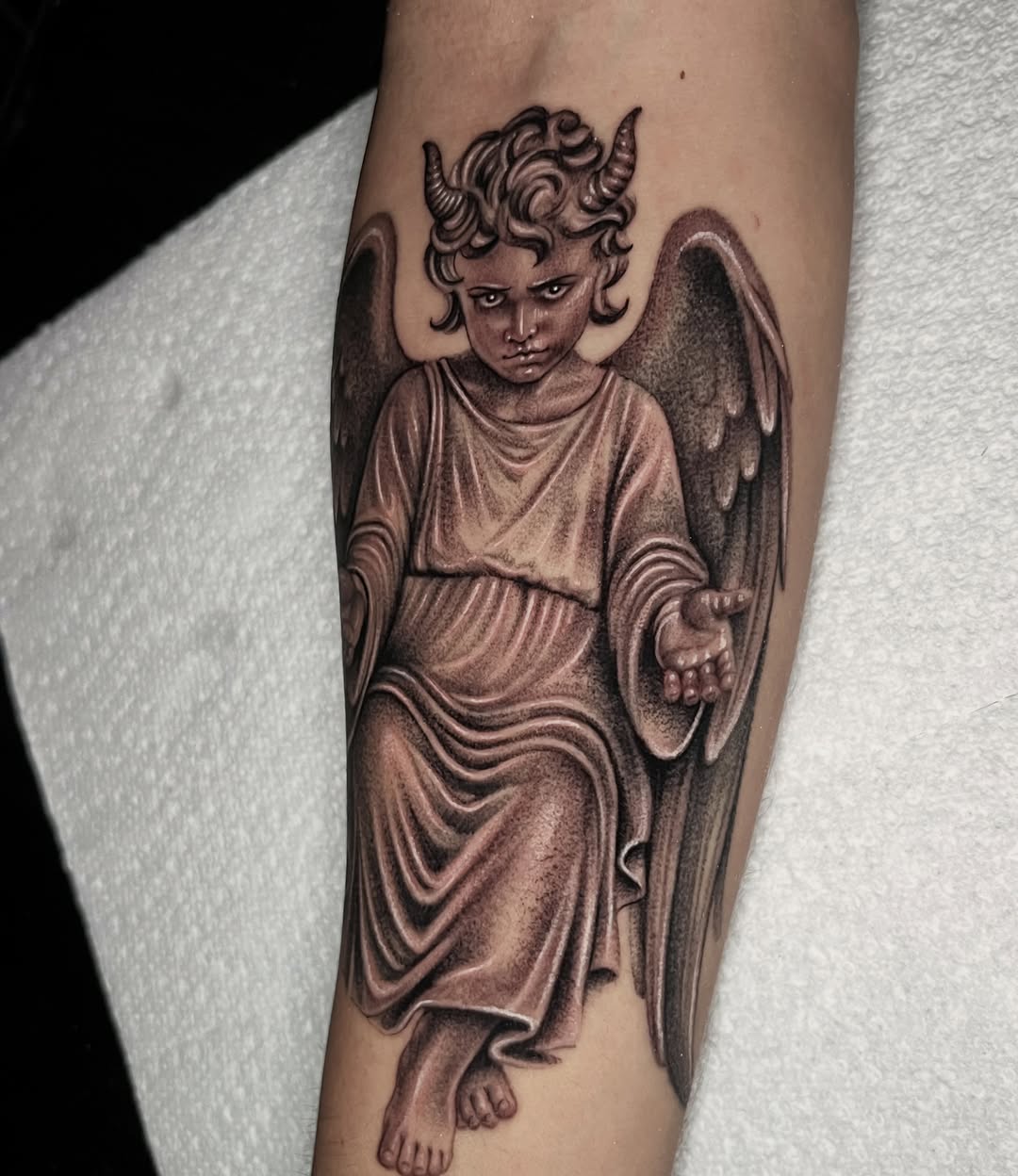 Cherub with horns and wings realism tattoo on the forearm by Single Needle ๐ชฉ