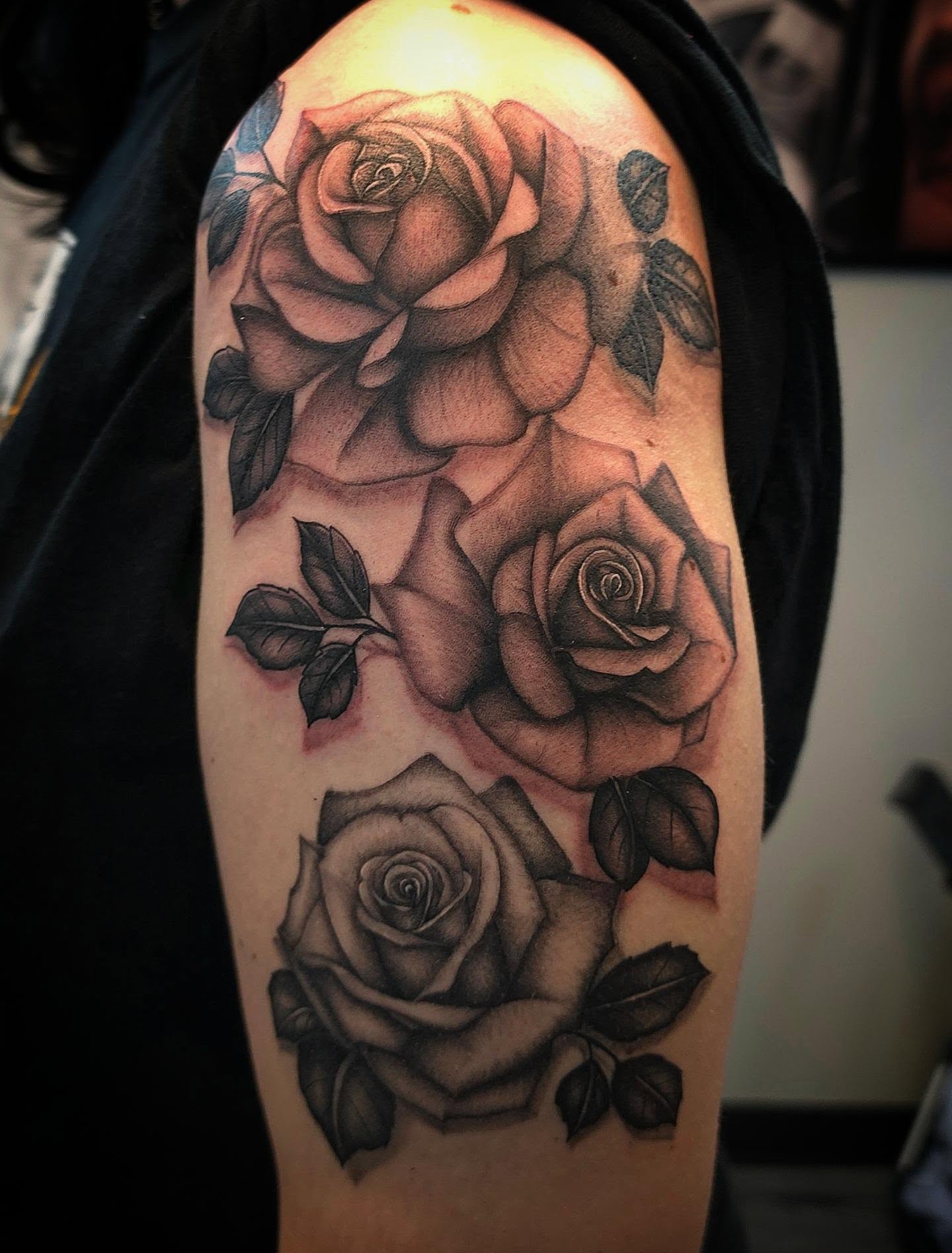 Roses black and grey tattoo on the upper arm by Danielle Elizabeth