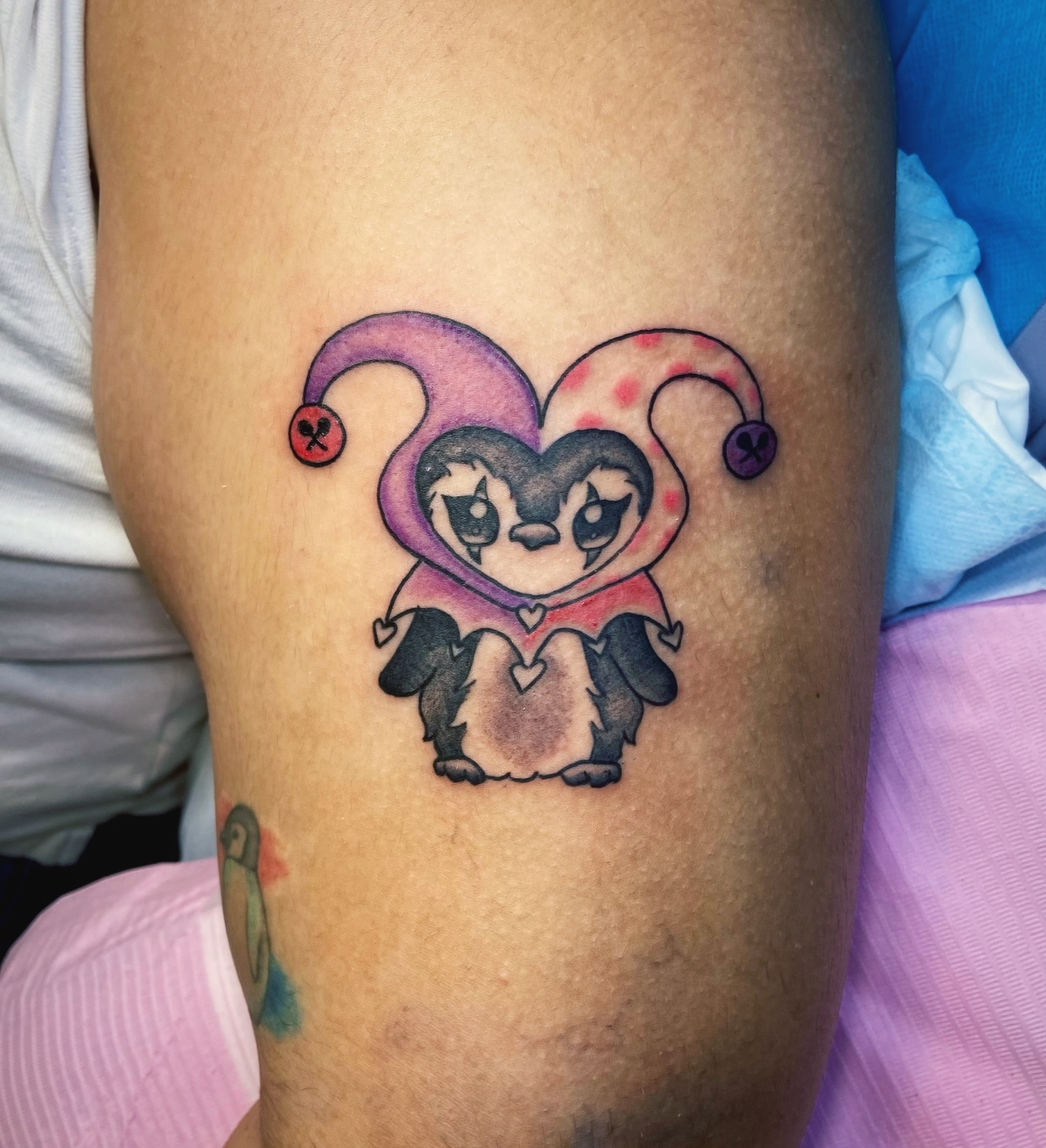 Jester penguin new school tattoo on the thigh by Shay Cole