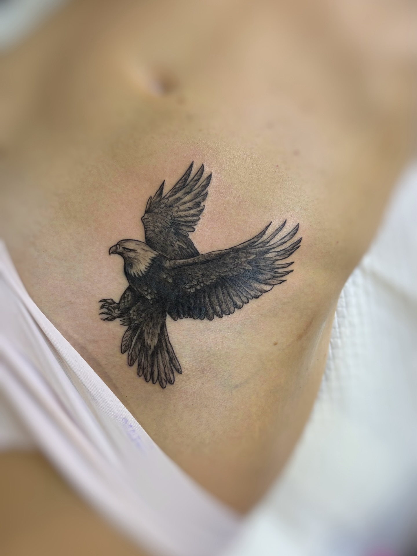 Flying eagle black and grey tattoo on the chest by Art by Aimee