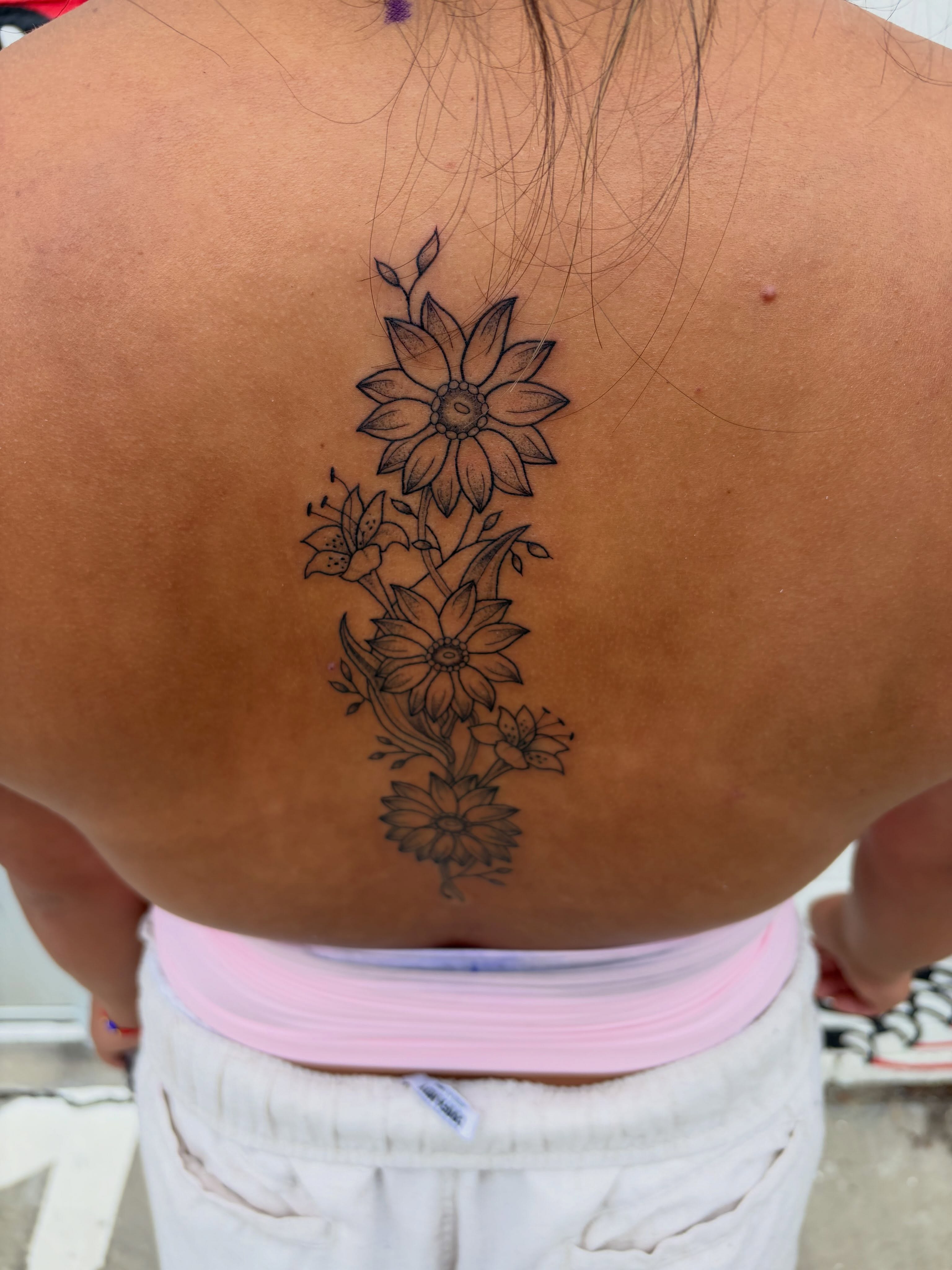 Flower bouquet black and grey tattoo on the back by Sarah Roach
