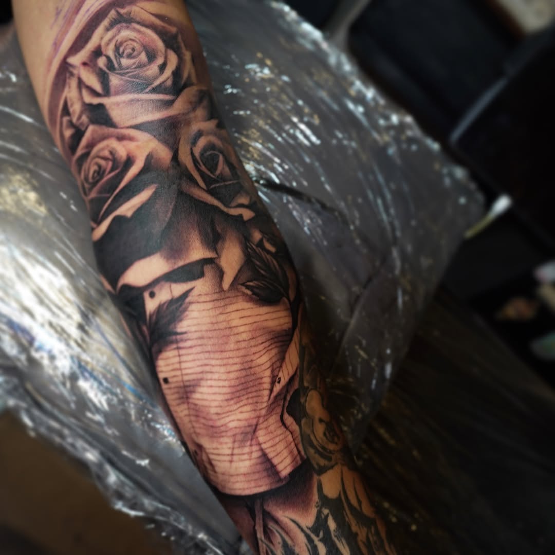 Roses and a face realism tattoo on the forearm by Erick Satchell II
