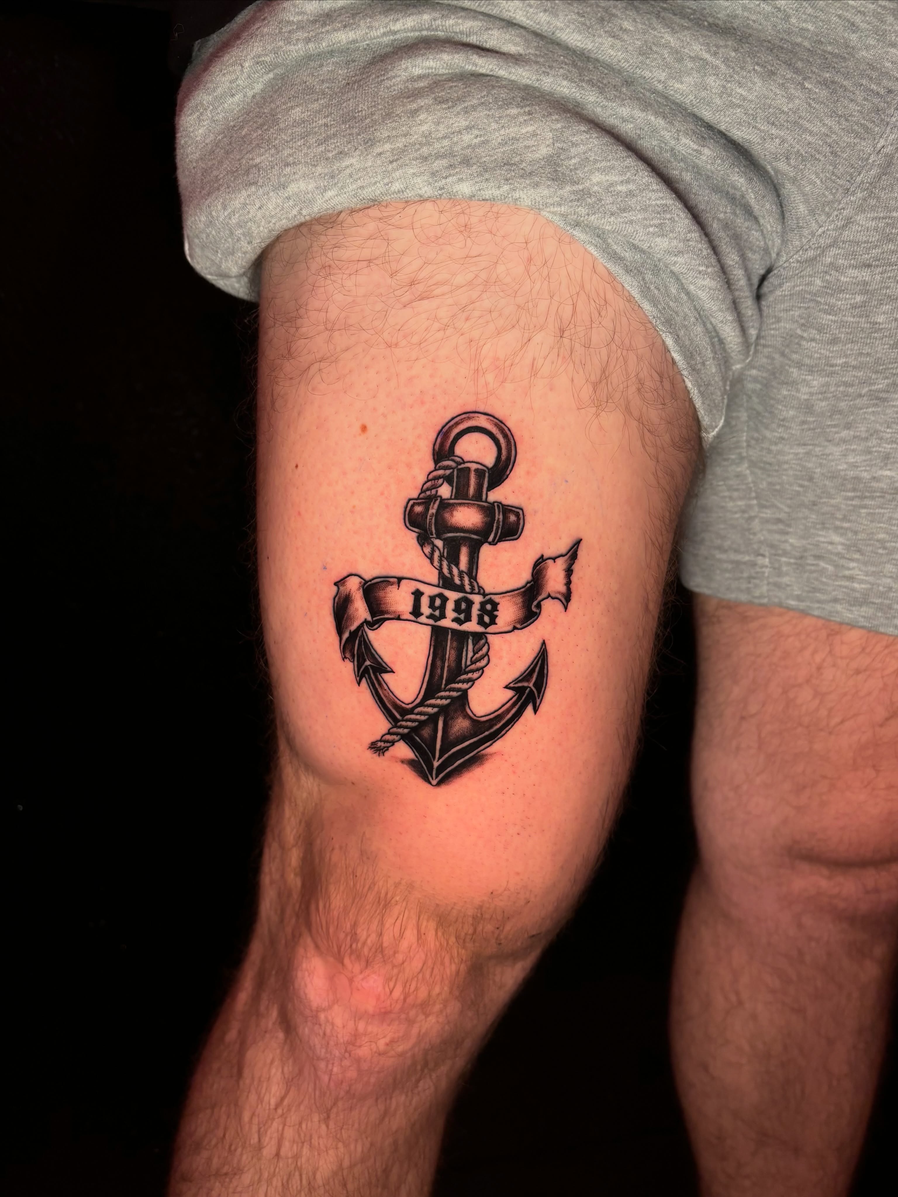 Anchor with banner black and grey tattoo on the thigh by JT.tattoos
