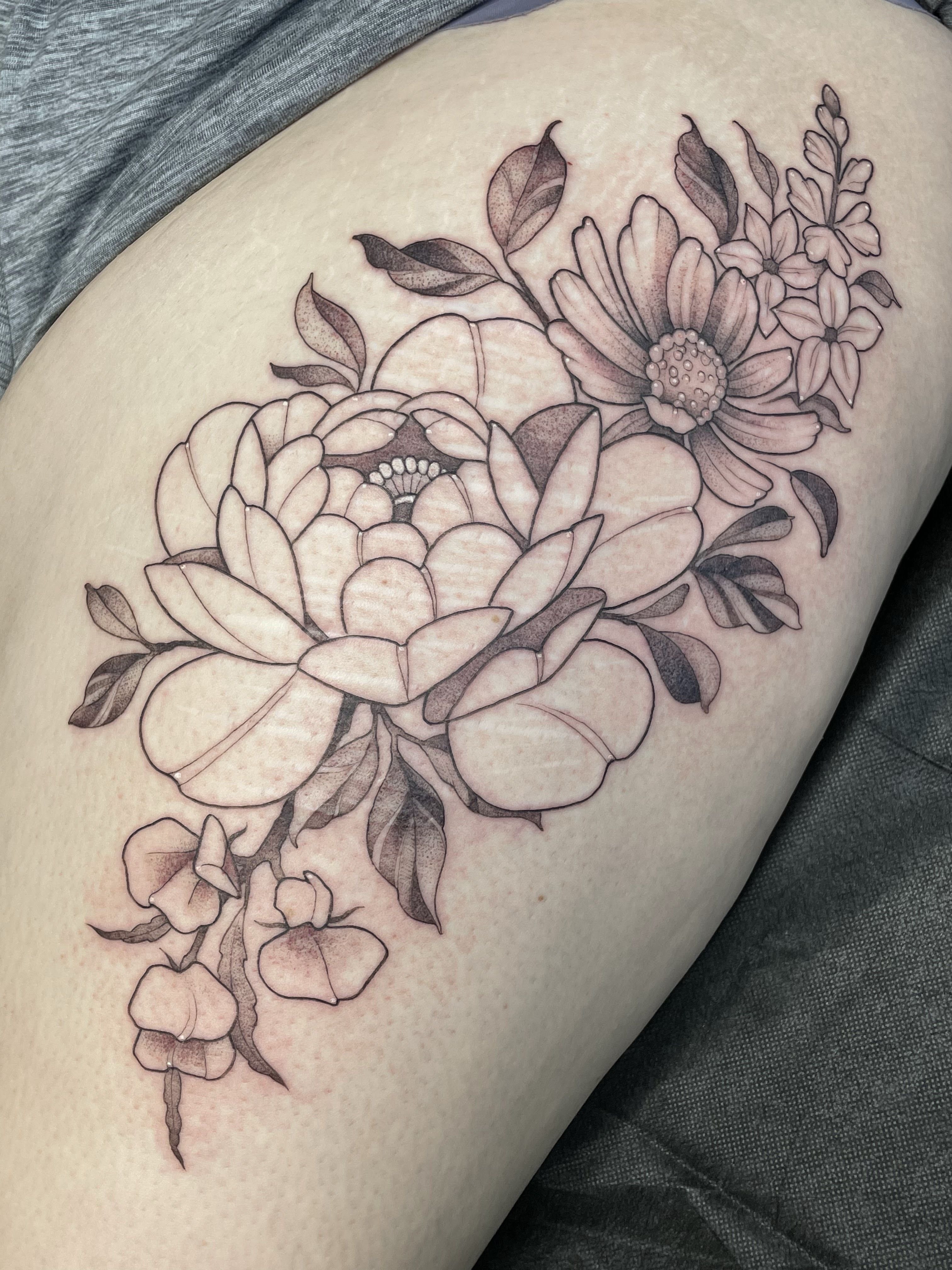 Floral bouquet black and grey tattoo on the thigh by Tanya Murski