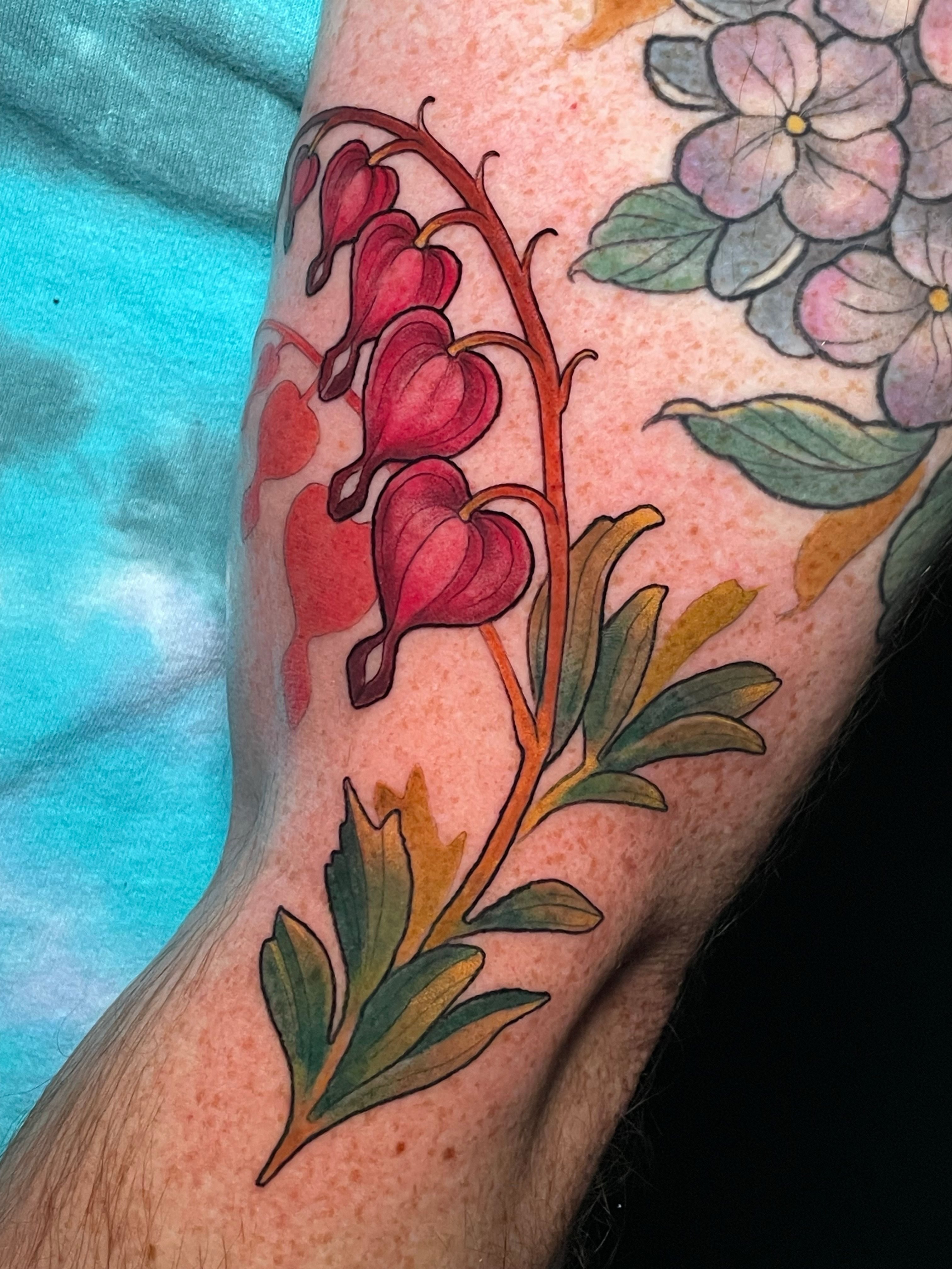 Bleeding heart flowers watercolor tattoo on the forearm by Tanya Murski