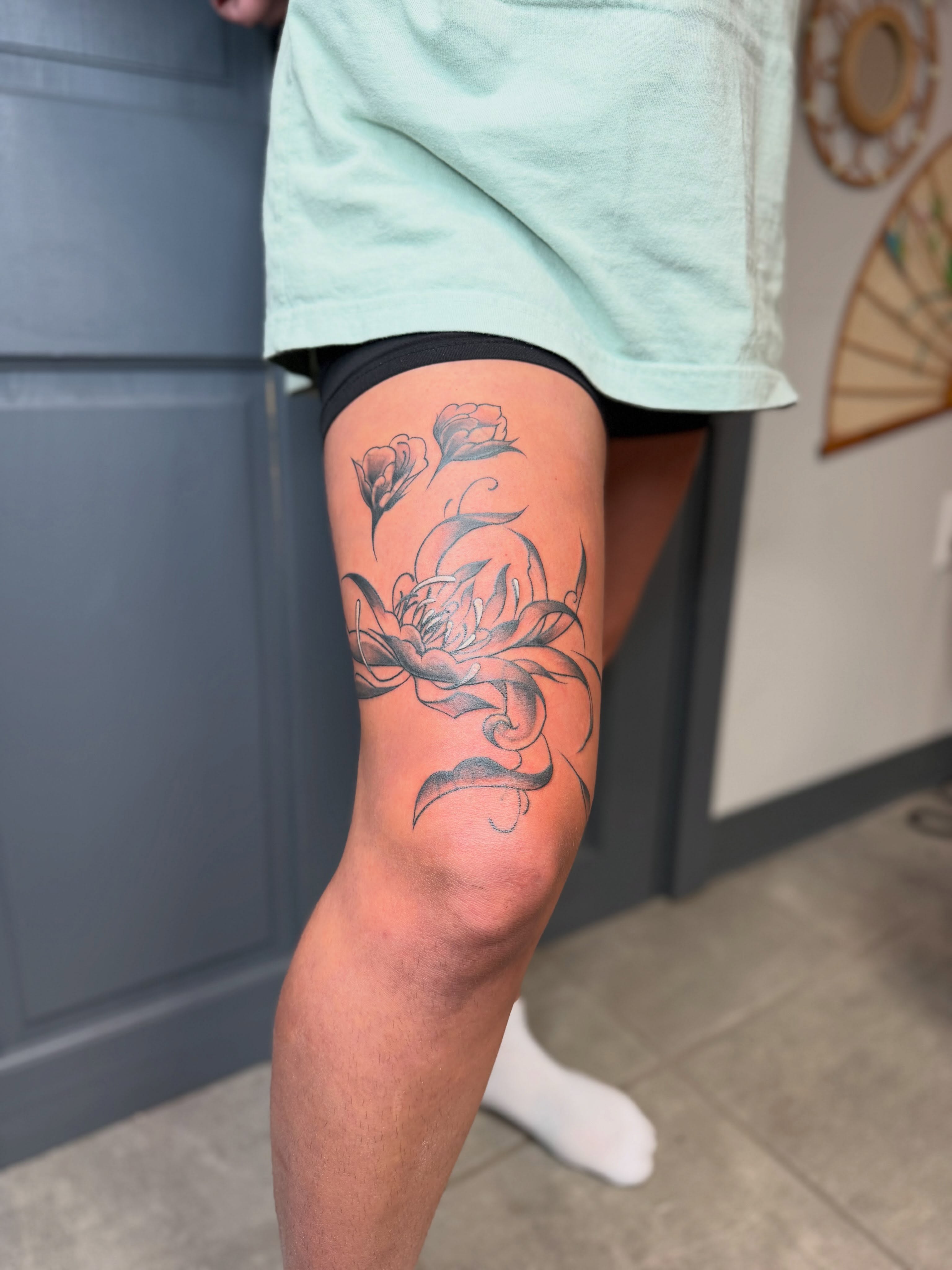 Floral design black and grey tattoo on the thigh by Summer Christman