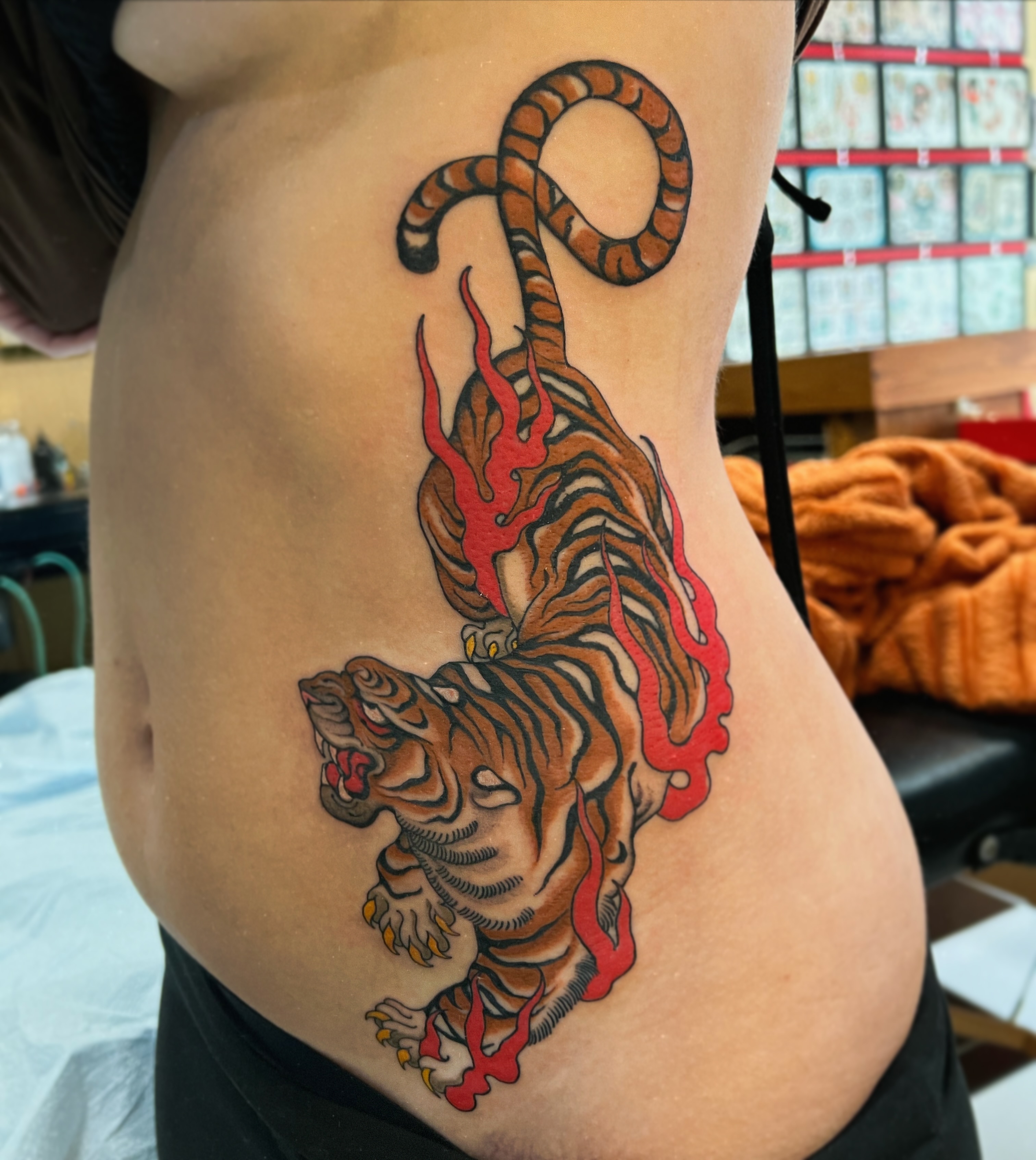 Tiger with flames American traditional tattoo on the ribs by superteal