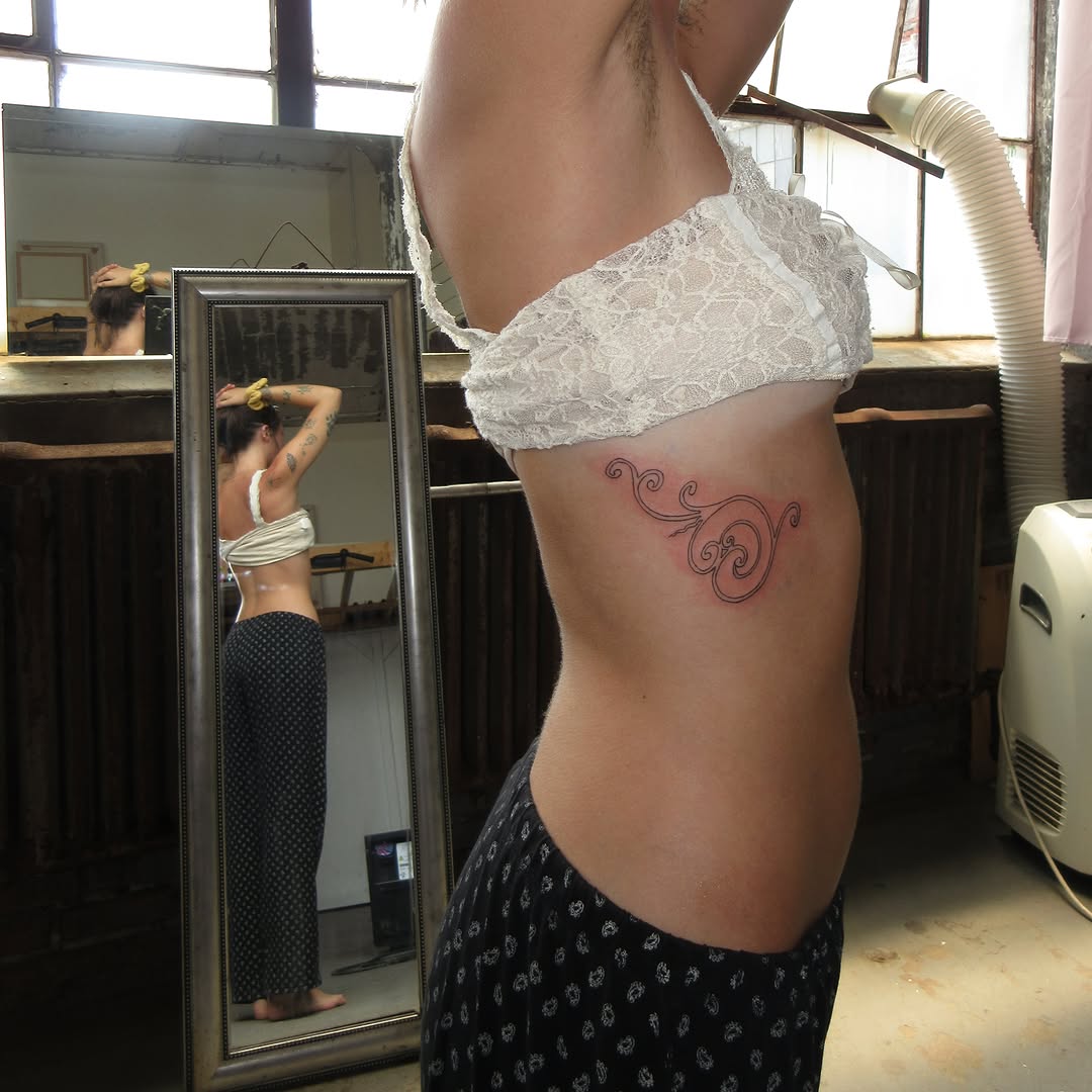 Scrollwork fine line tattoo on the ribs by bisabuelita