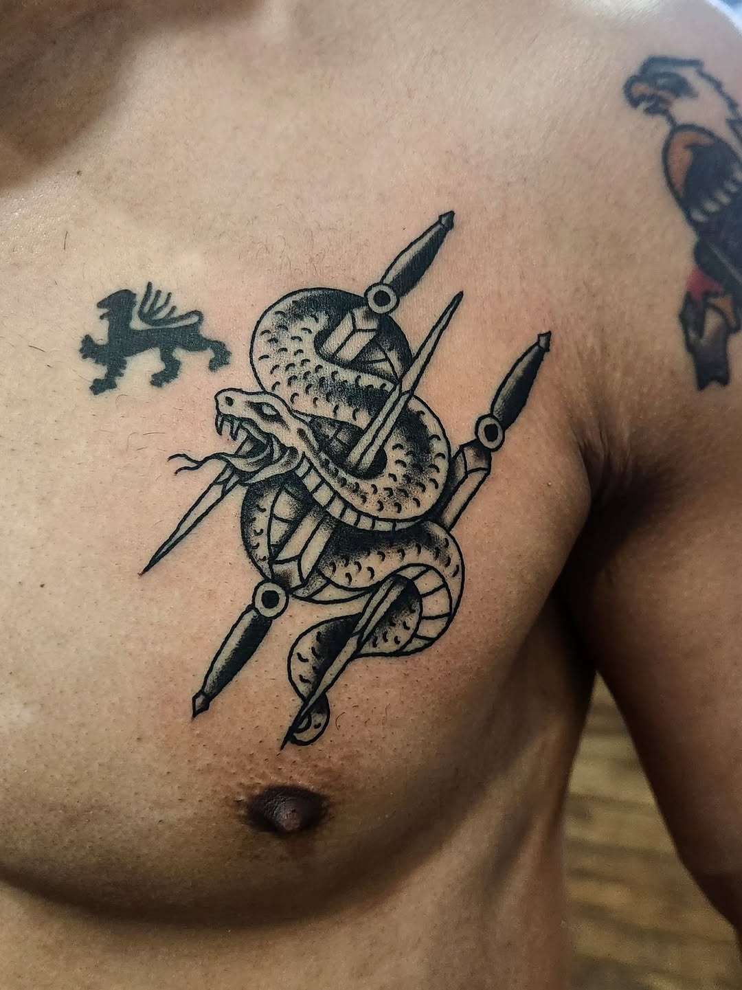 Snake and daggers American traditional tattoo on the chest by Douglas Grady
