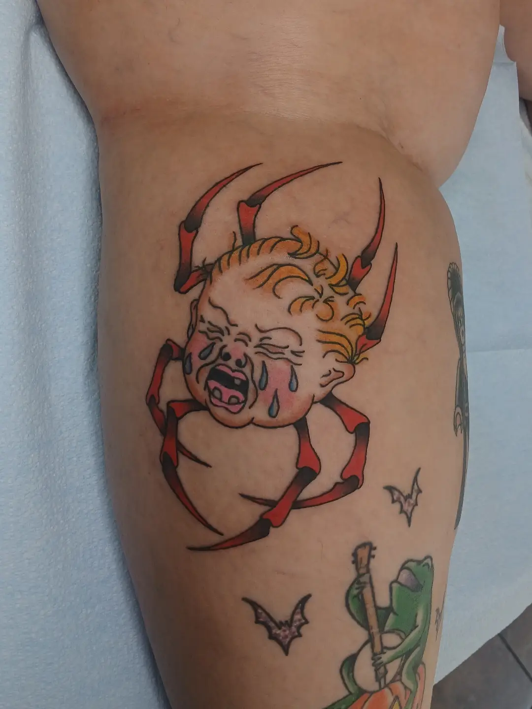 Crying devil baby American traditional tattoo on the thigh by Amber Tattoos