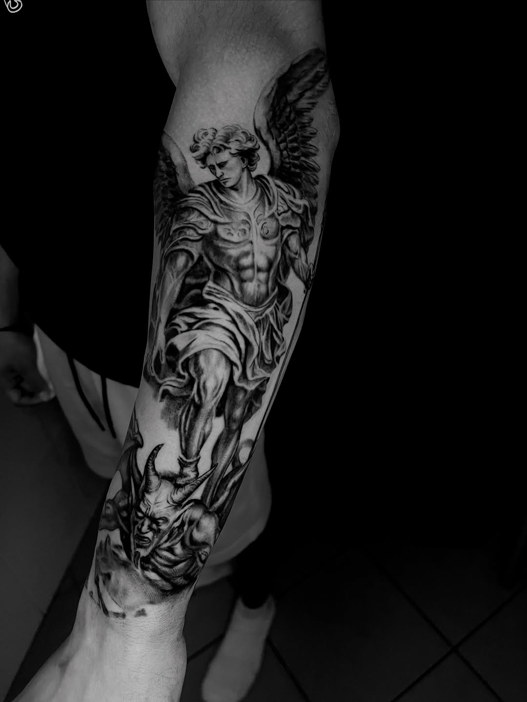 Angel battling demon realism tattoo on the forearm by Tattoo Artist