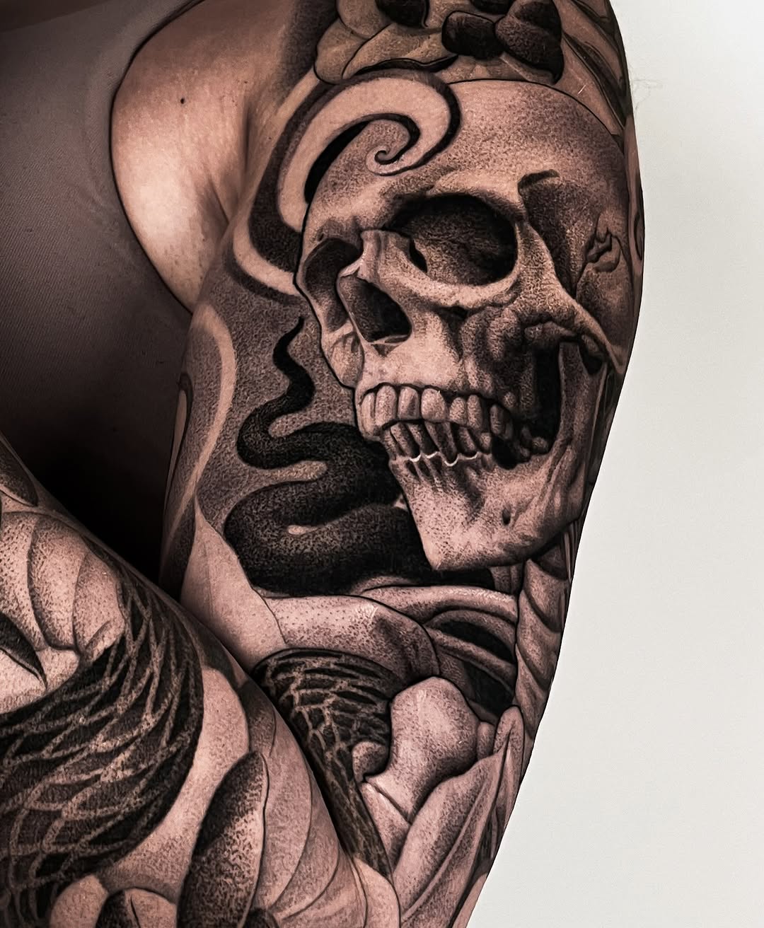 Skull and snake realism tattoo on the forearm by Enrique Martinez