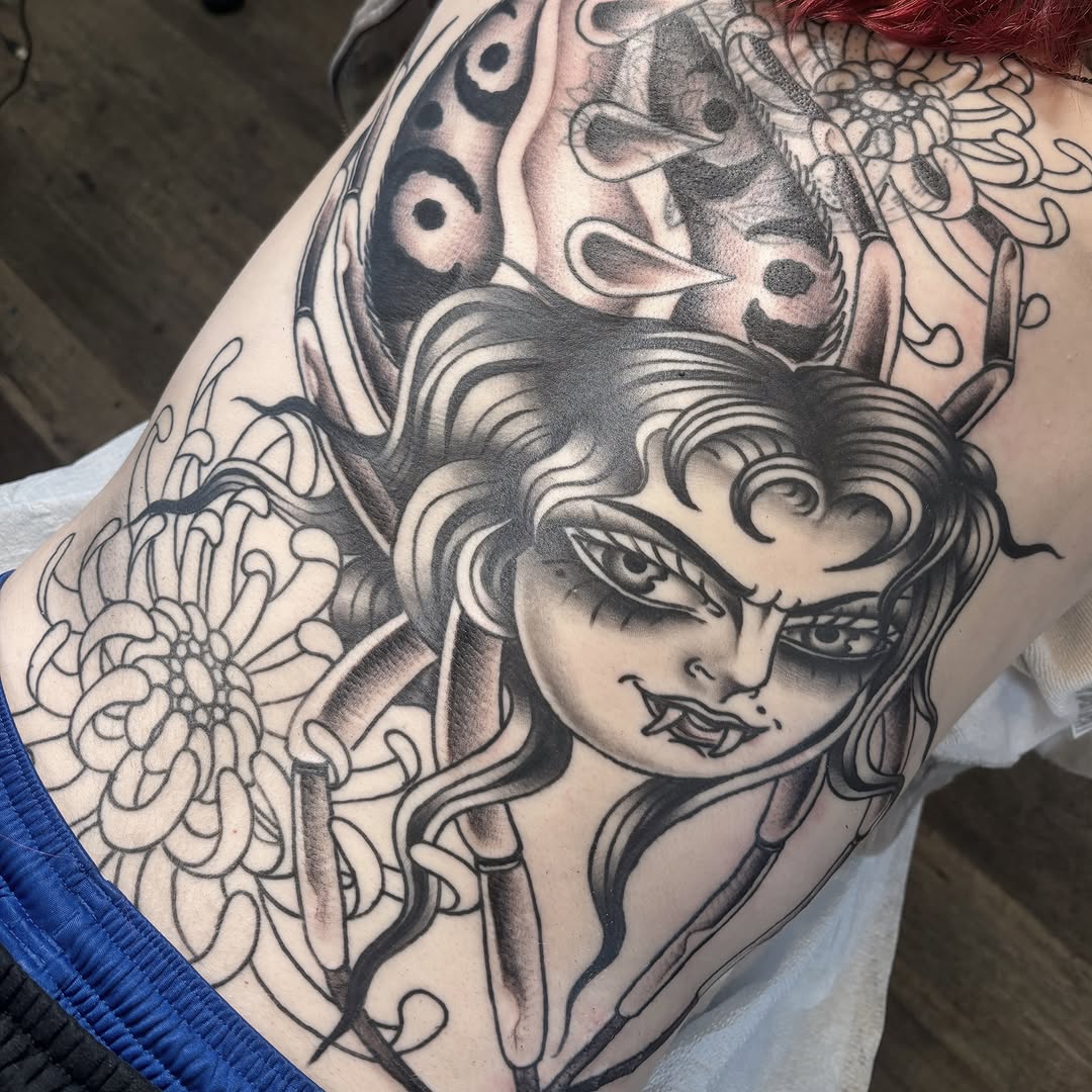 Woman with long hair American traditional tattoo on the shoulder by Caeli Martin
