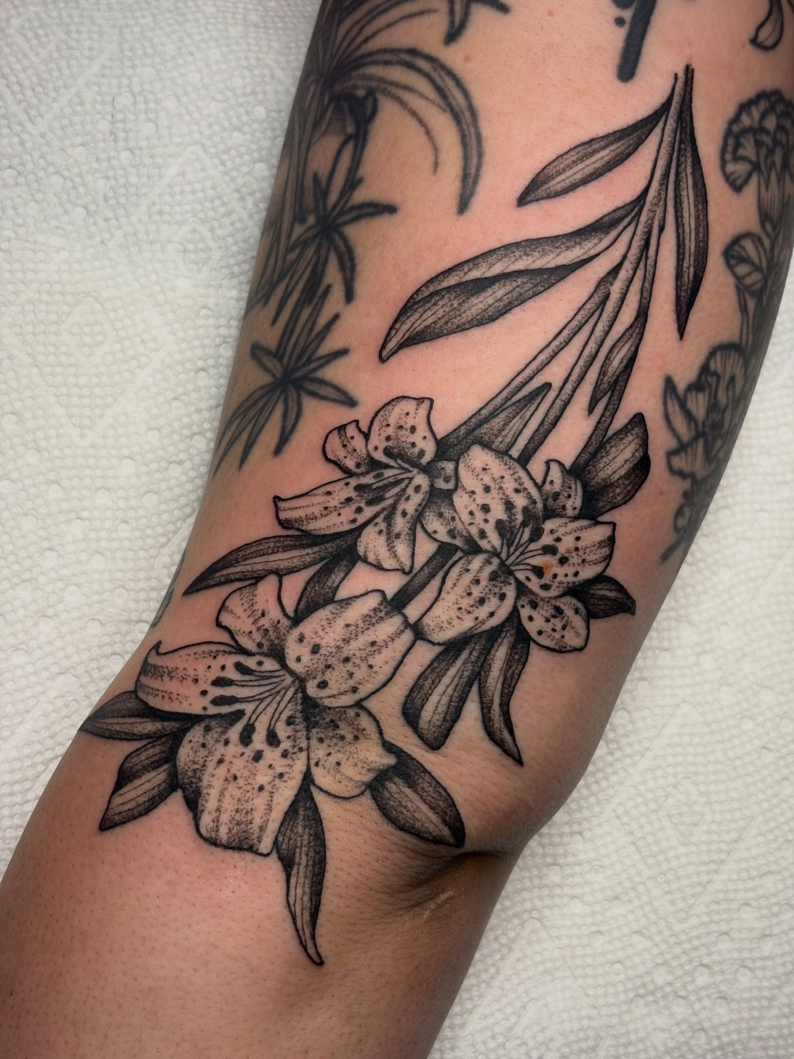 Lilies dotwork tattoo on the forearm by Sydney Pflaumer
