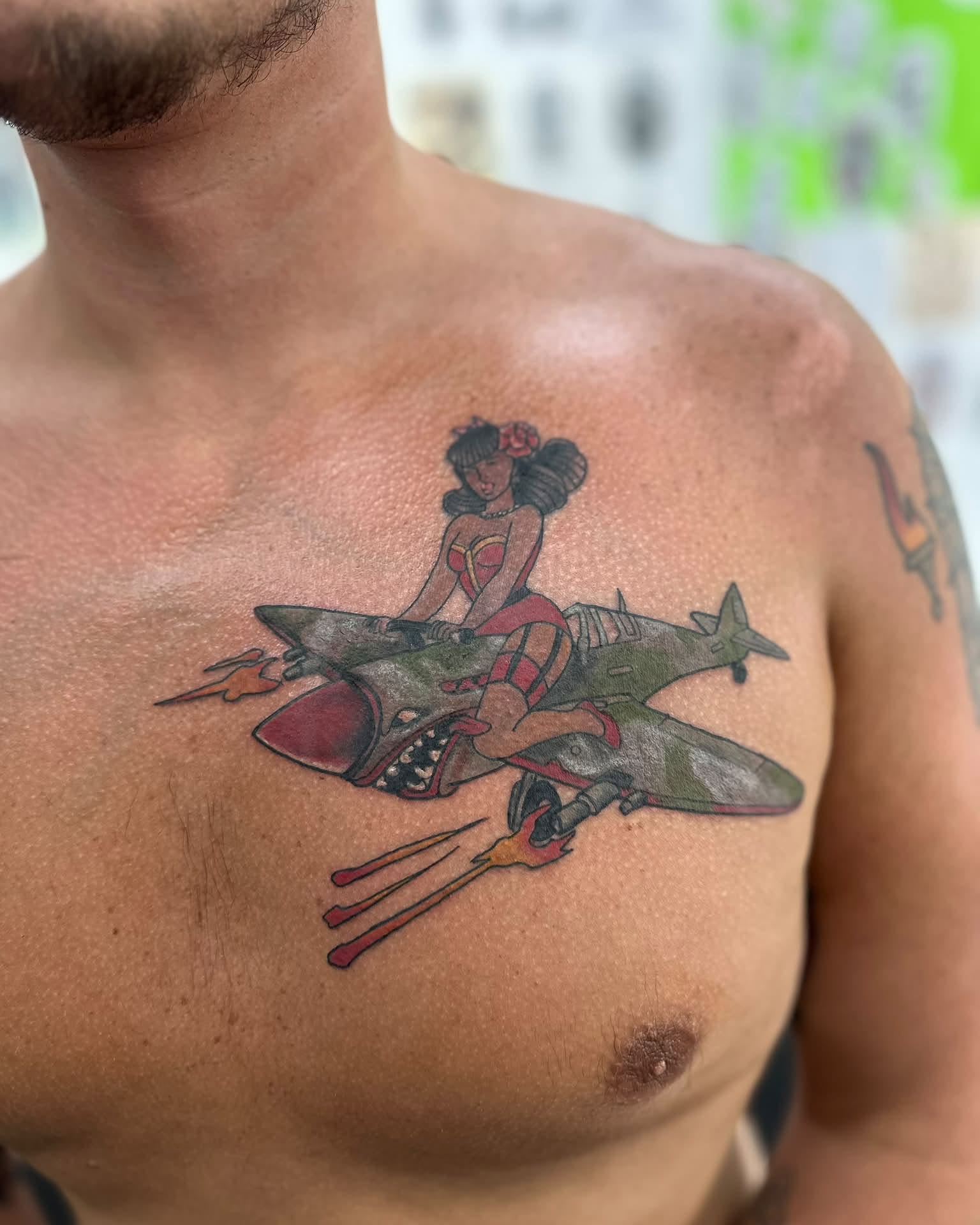 Airplane and pin-up girl American traditional tattoo on the chest by Brian Lambert