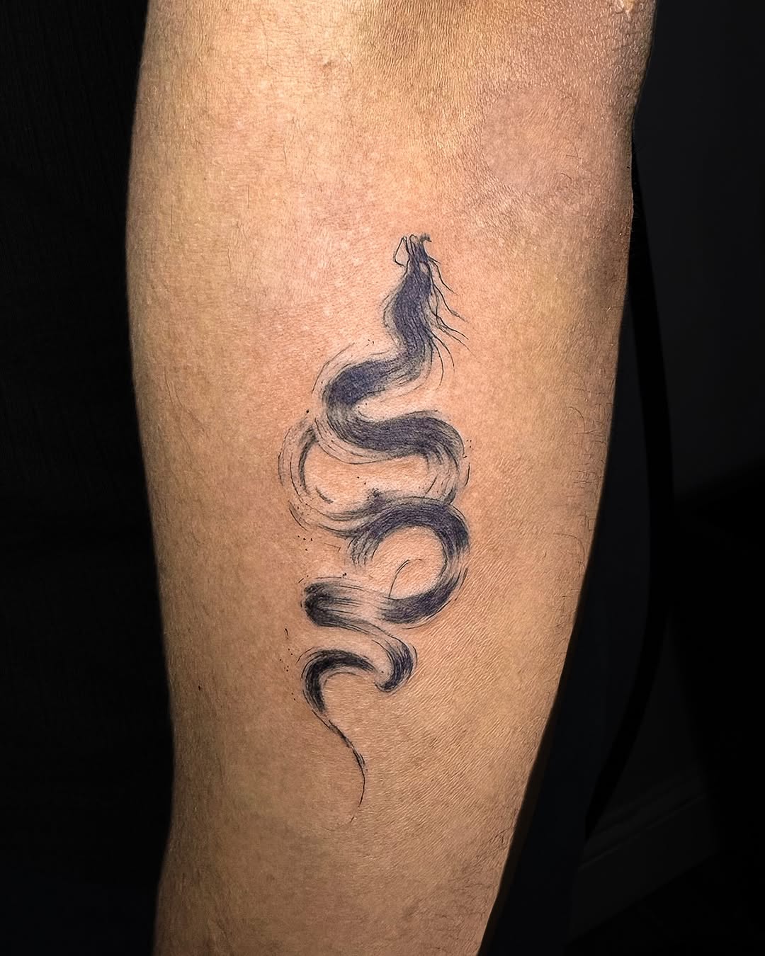Abstract snake watercolor tattoo on the forearm by INK by CEE