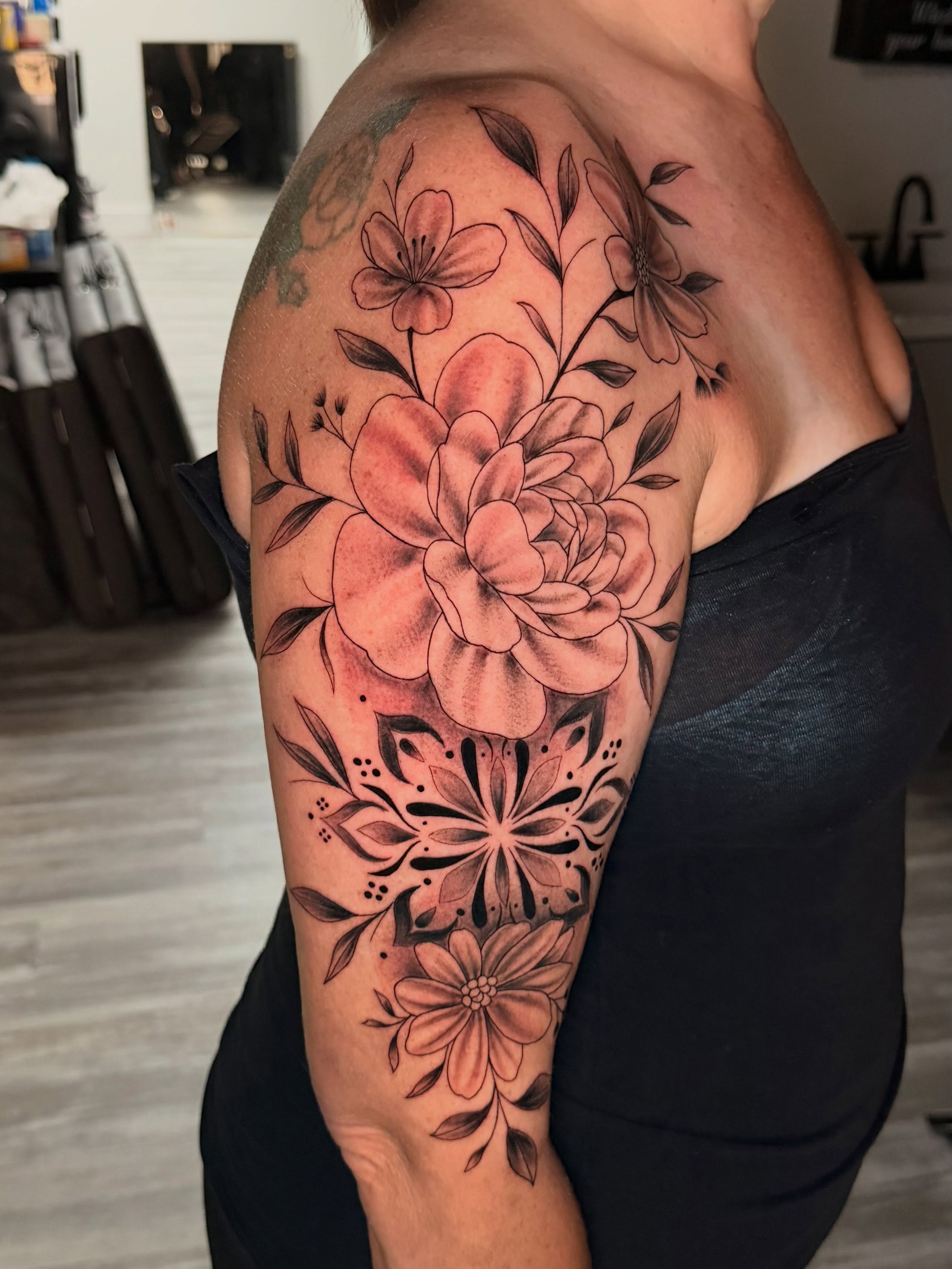 Floral arrangement black and grey tattoo on the upper arm by Breanna💉🔮, Dover, Delaware