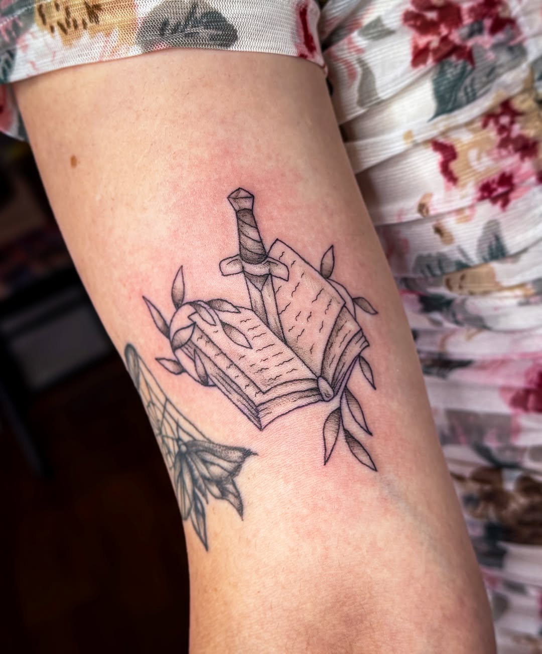 Book and dagger black and grey tattoo on the forearm by Ash✨