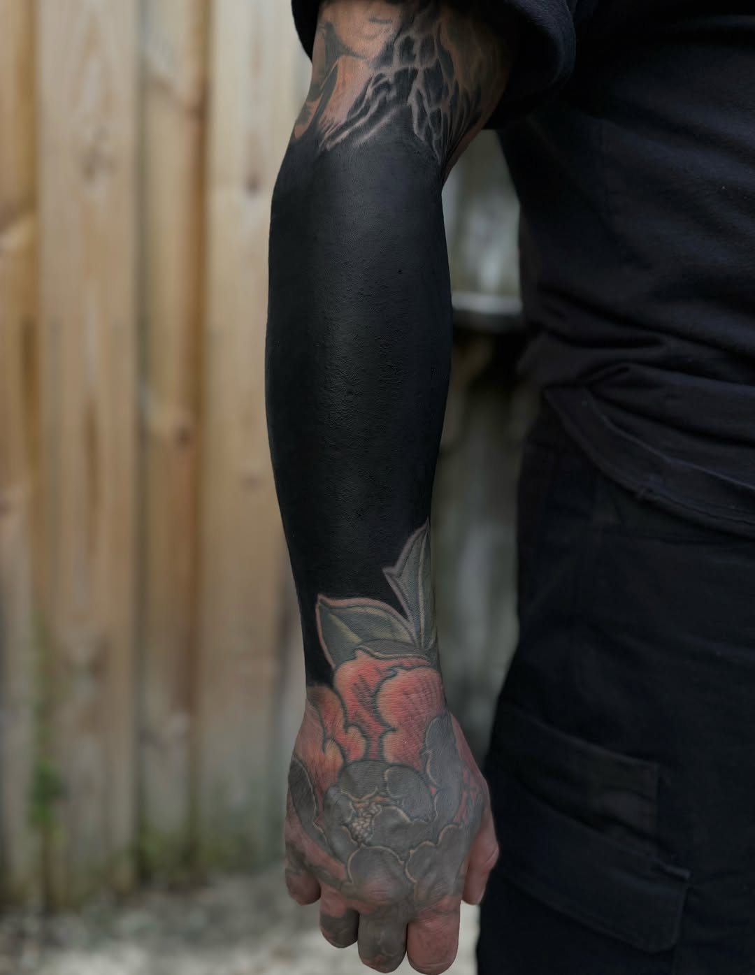Blackout sleeve with floral elements tribal tattoo on the forearm by Jesse White, Mentor, Ohio