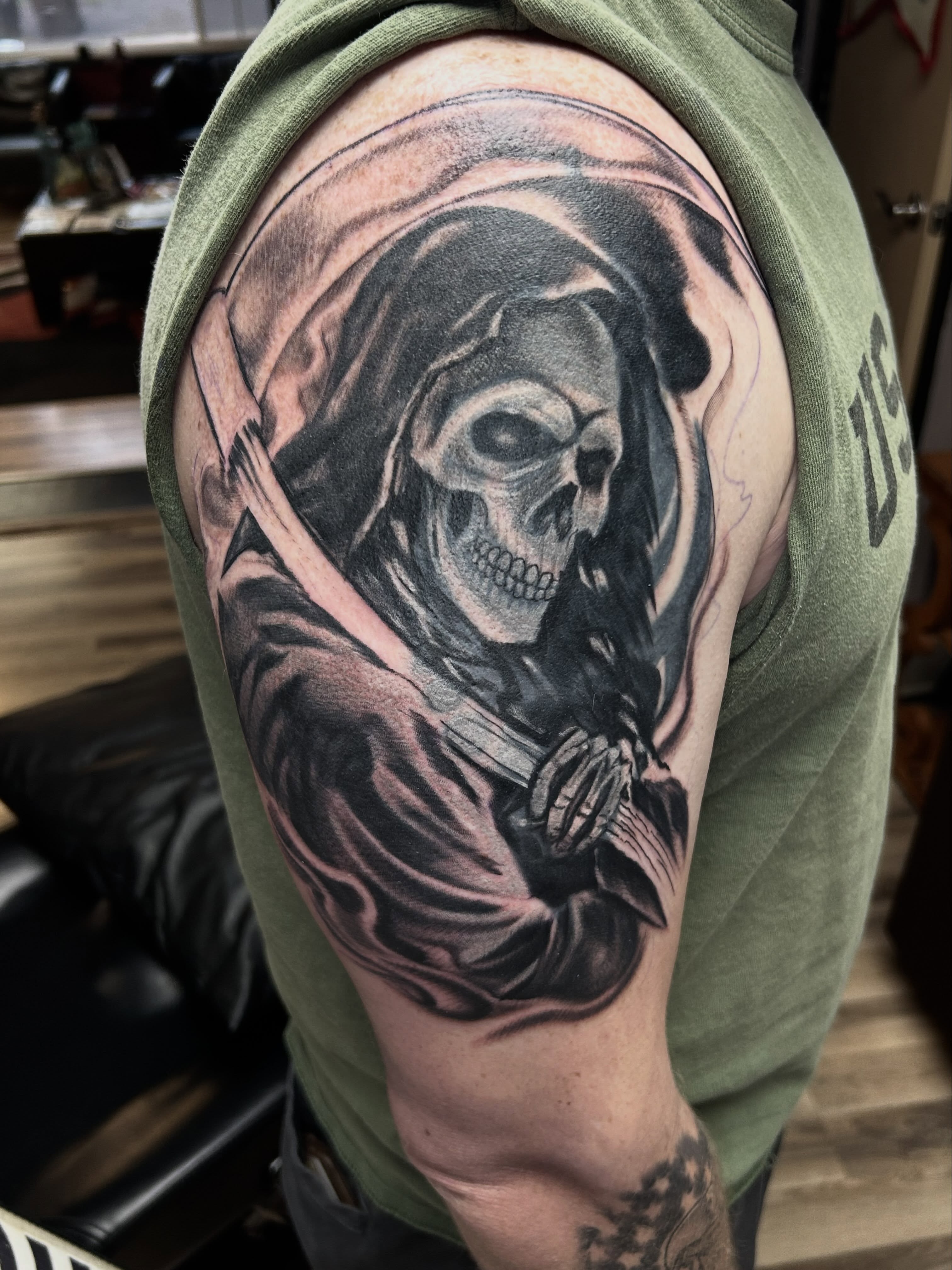 Grim reaper realism tattoo on the upper arm by Dan Schuster