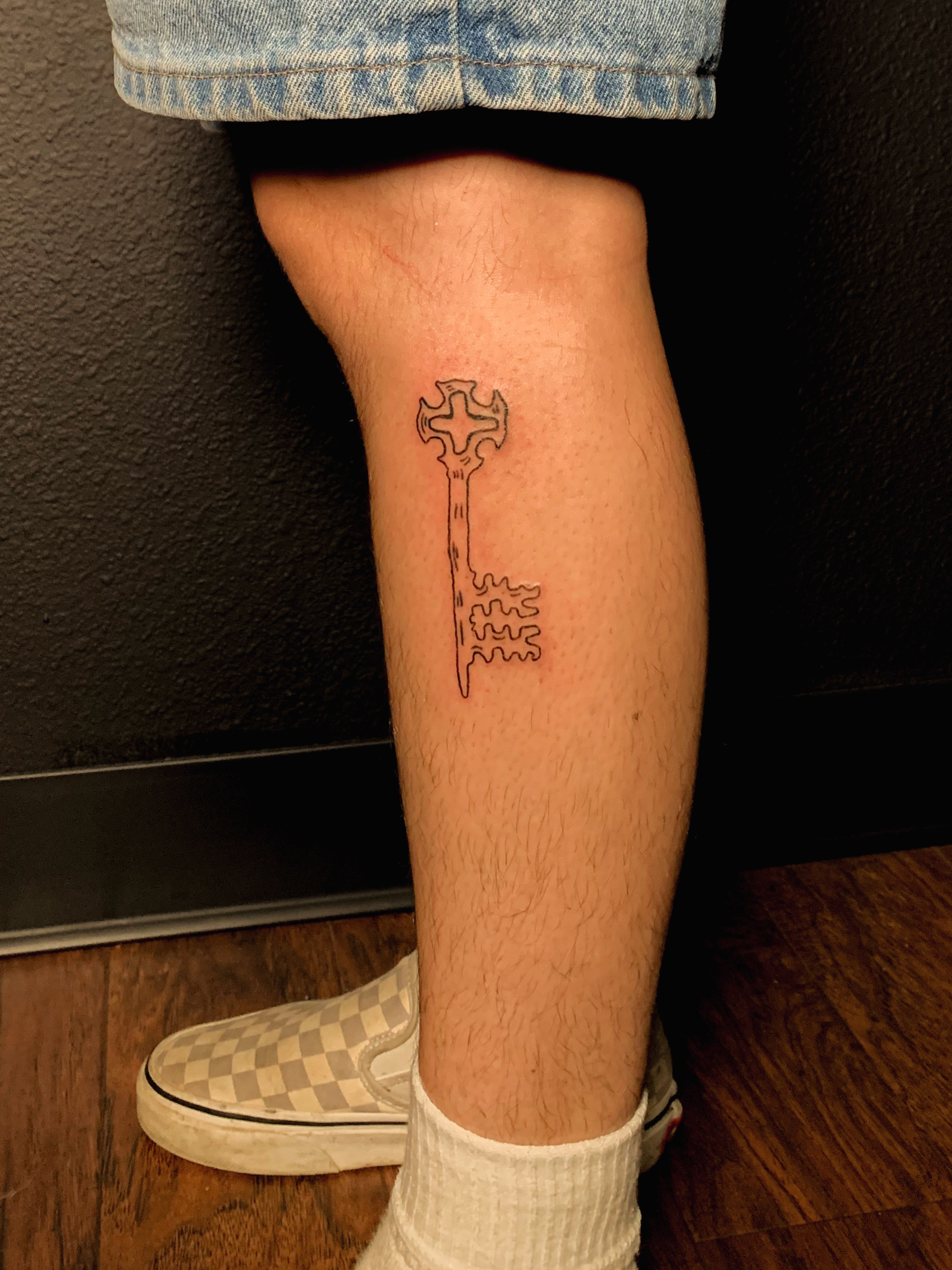 Key black and grey tattoo on the calf by charles