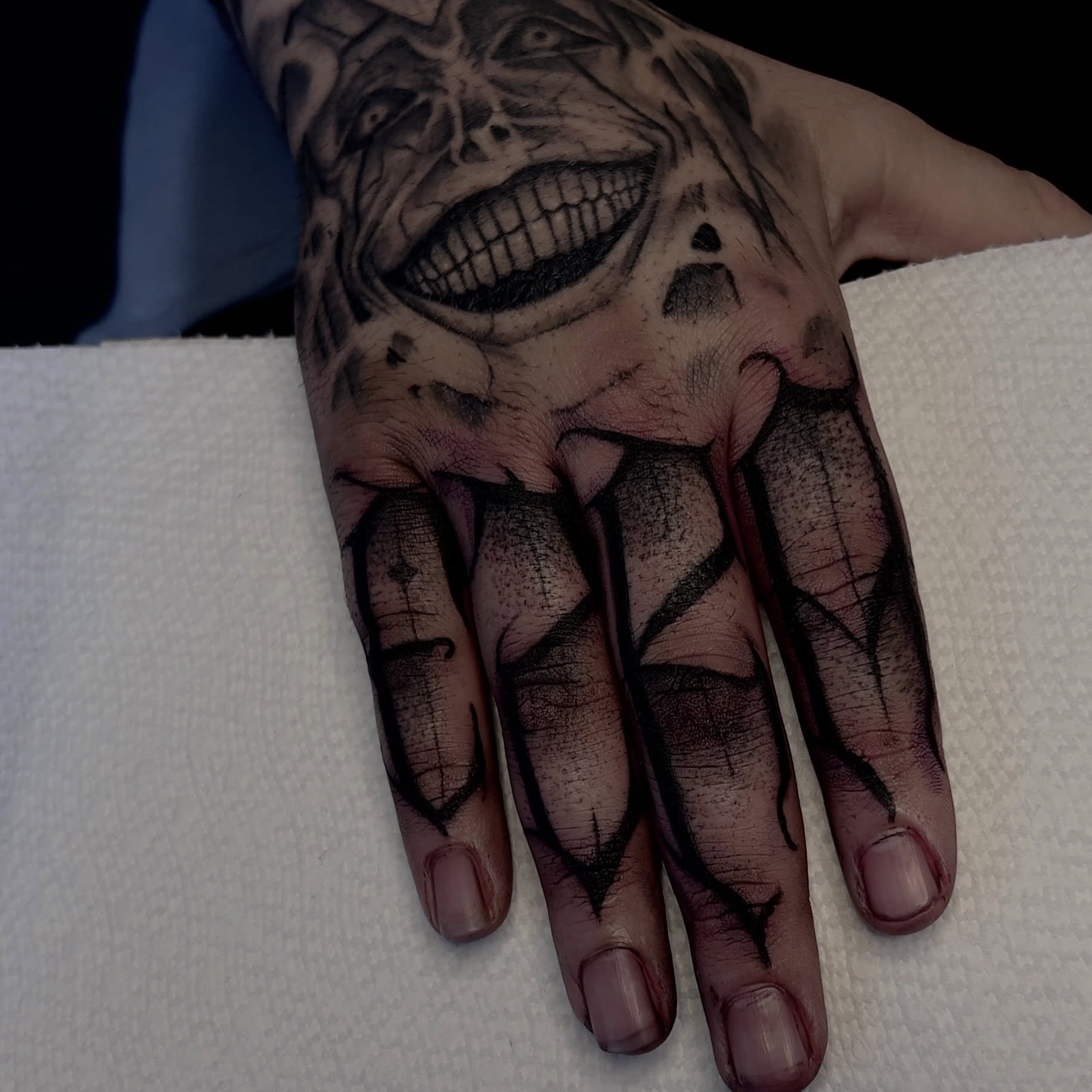 Grimacing face dark realism tattoo on the hand by David Carras-pol, Miramar, Florida