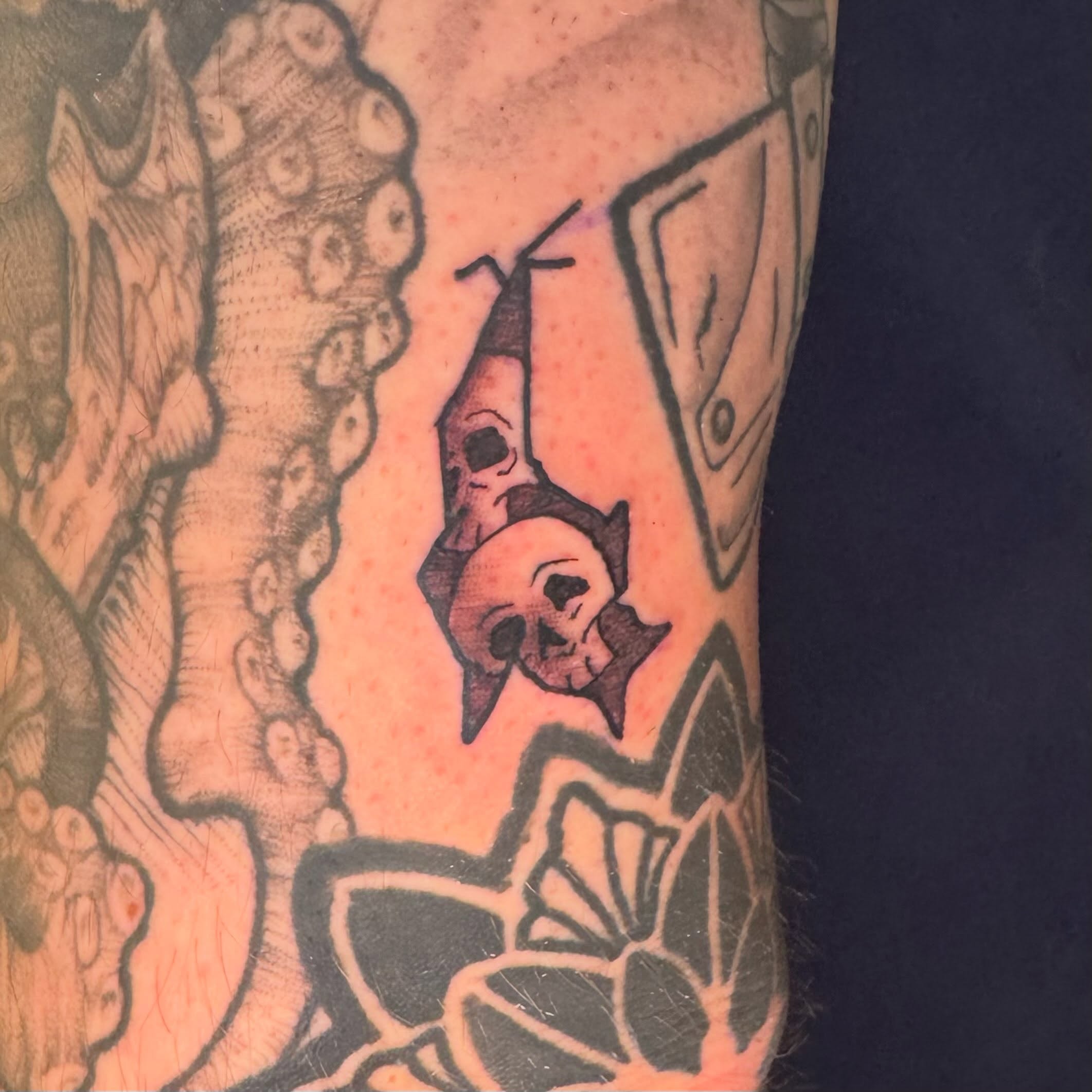 Skulls and tentacles black and grey tattoo on the forearm by Zac Smith-Chevalier