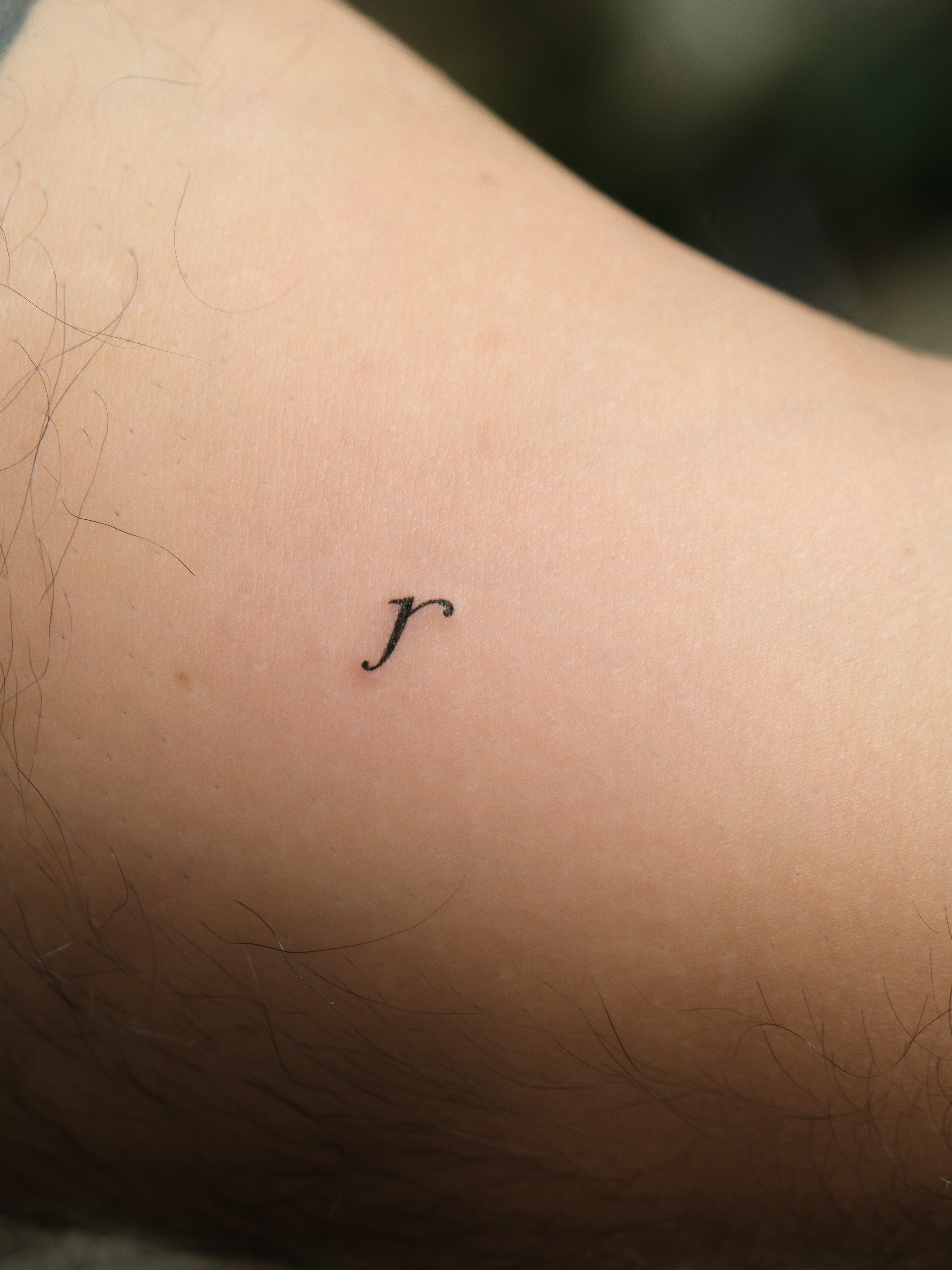 Letter 'r' lettering script tattoo on the forearm by Victoria
