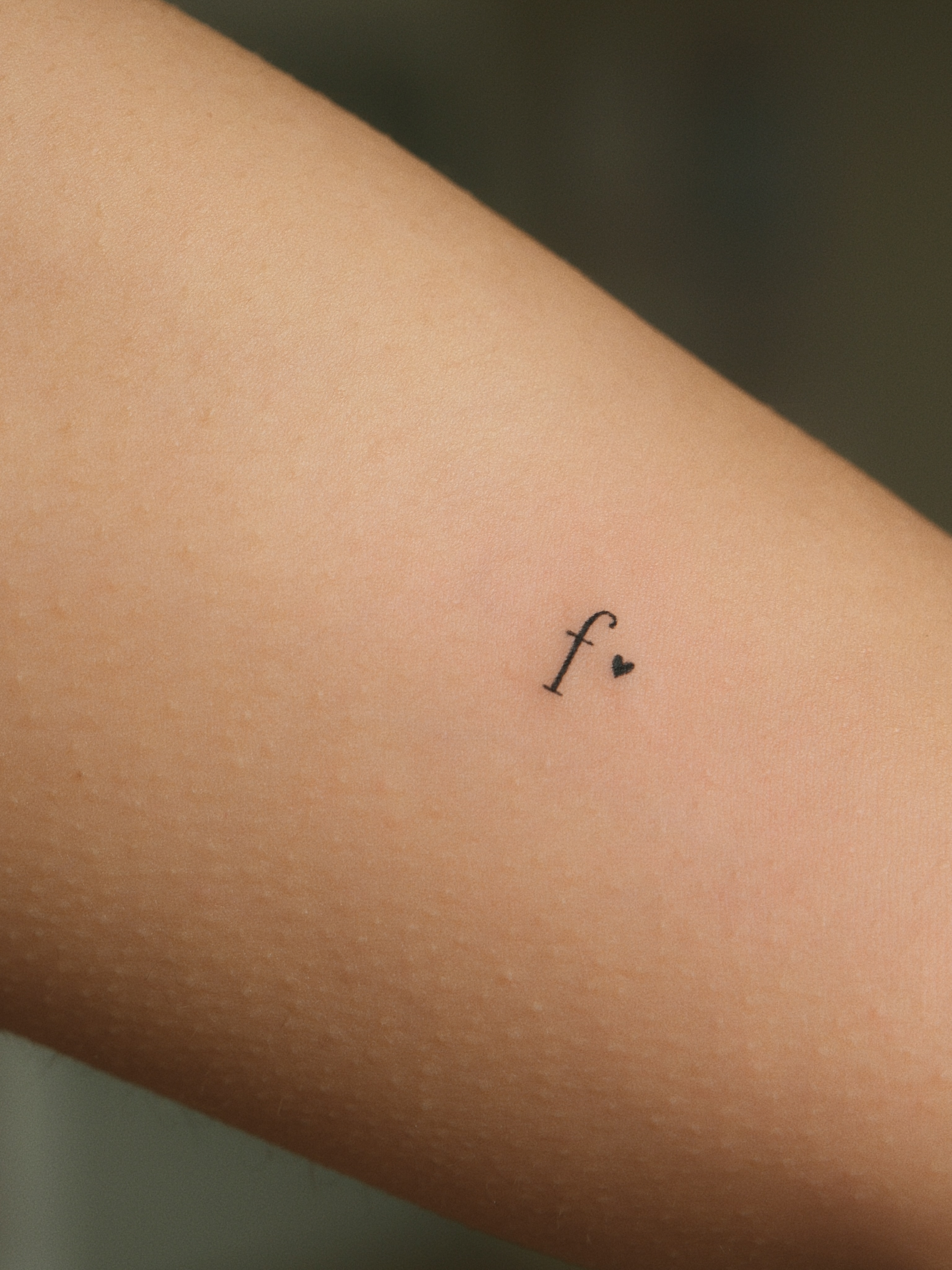 Letter f fine line tattoo on the forearm by Victoria