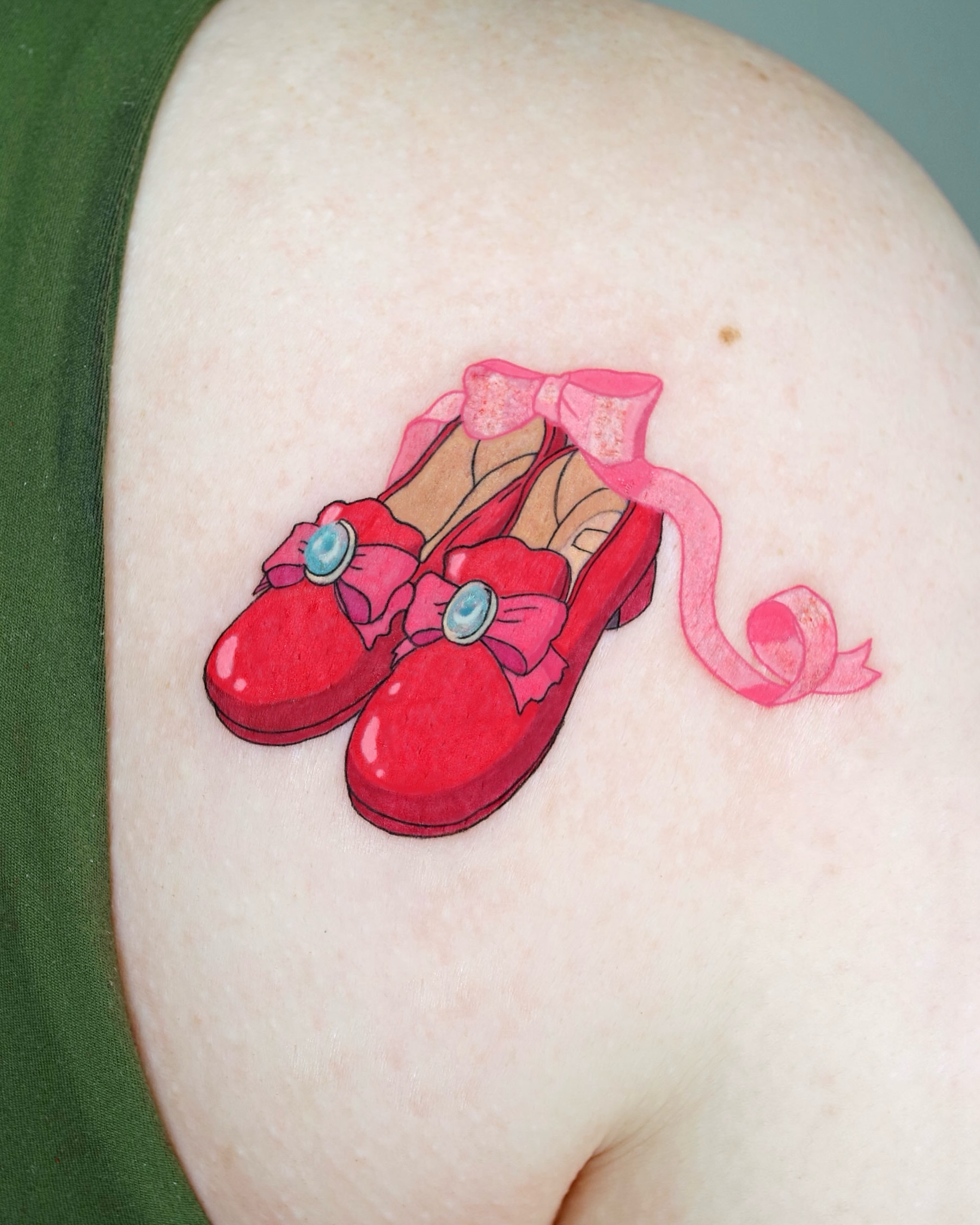 Ruby slippers illustrative tattoo on the shoulder by Aroha