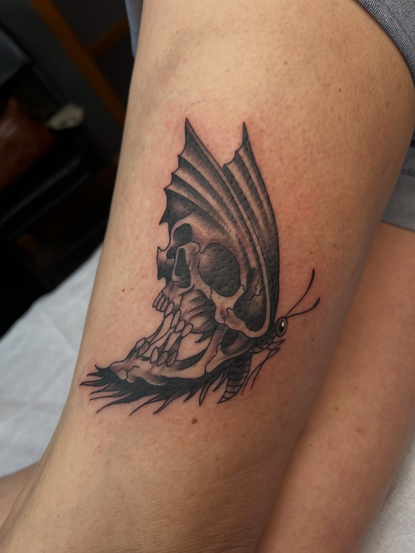Skull and butterfly realism tattoo on the thigh by Tyler Van Pelt