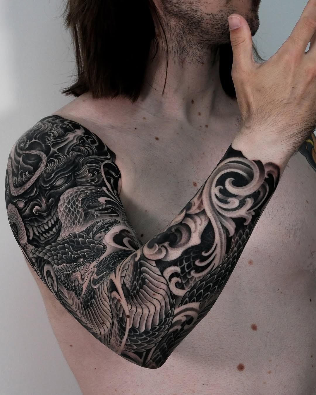 Dragon and mask Japanese tattoo on the upper arm by Yujin Ju