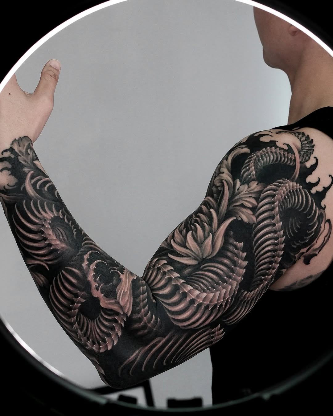 Dragon scales and floral elements Japanese tattoo on the upper arm by Yujin Ju