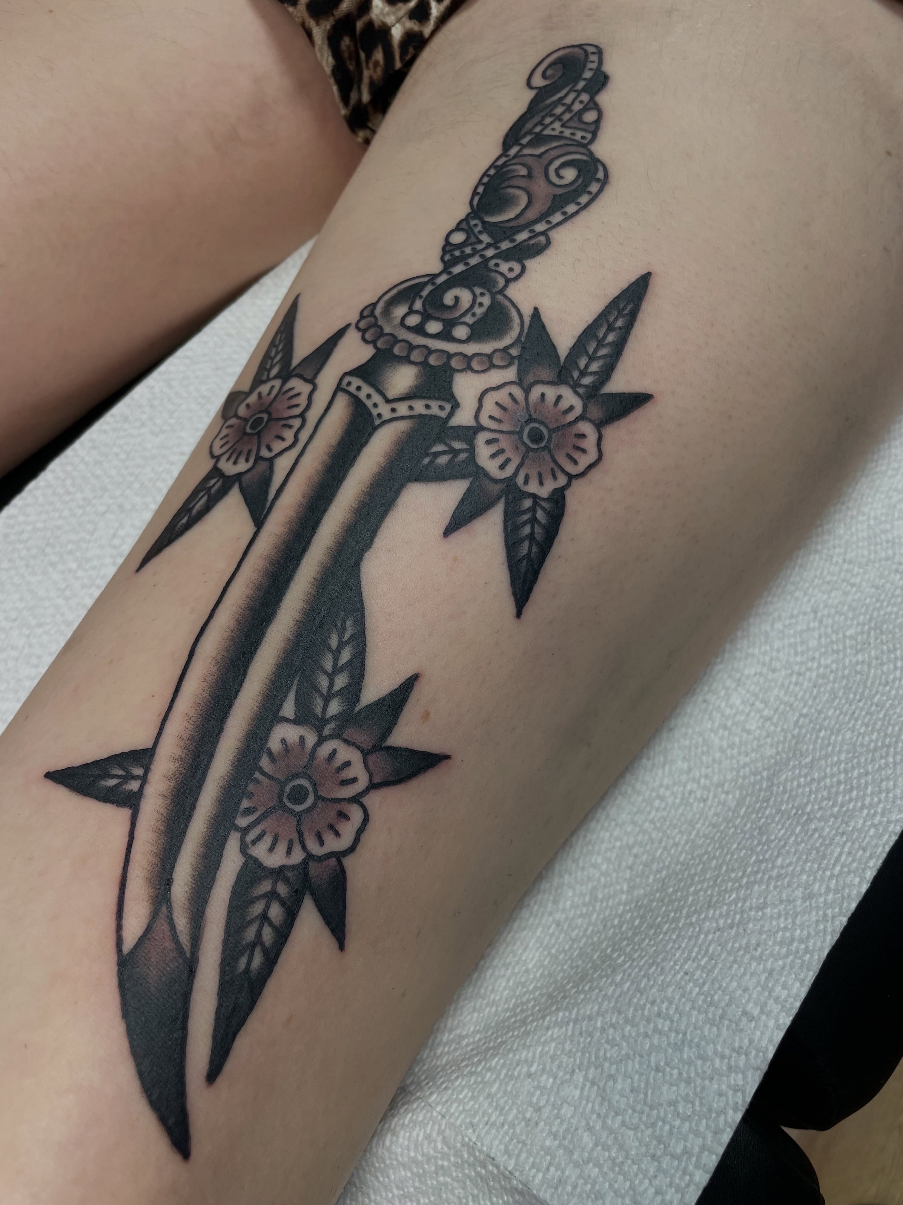 Sword and flowers black and grey tattoo on the forearm by @pizzabref