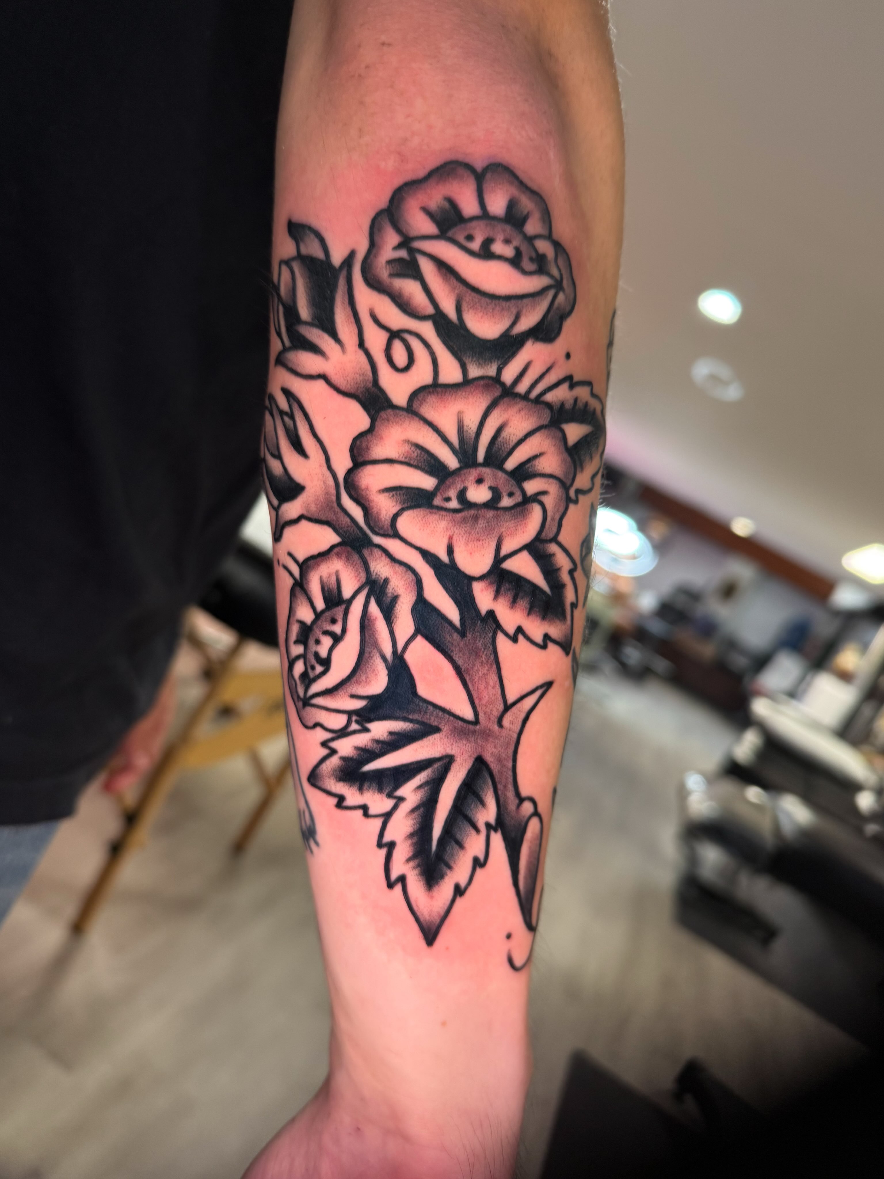 Flowers American traditional tattoo on the forearm by Louie Flores