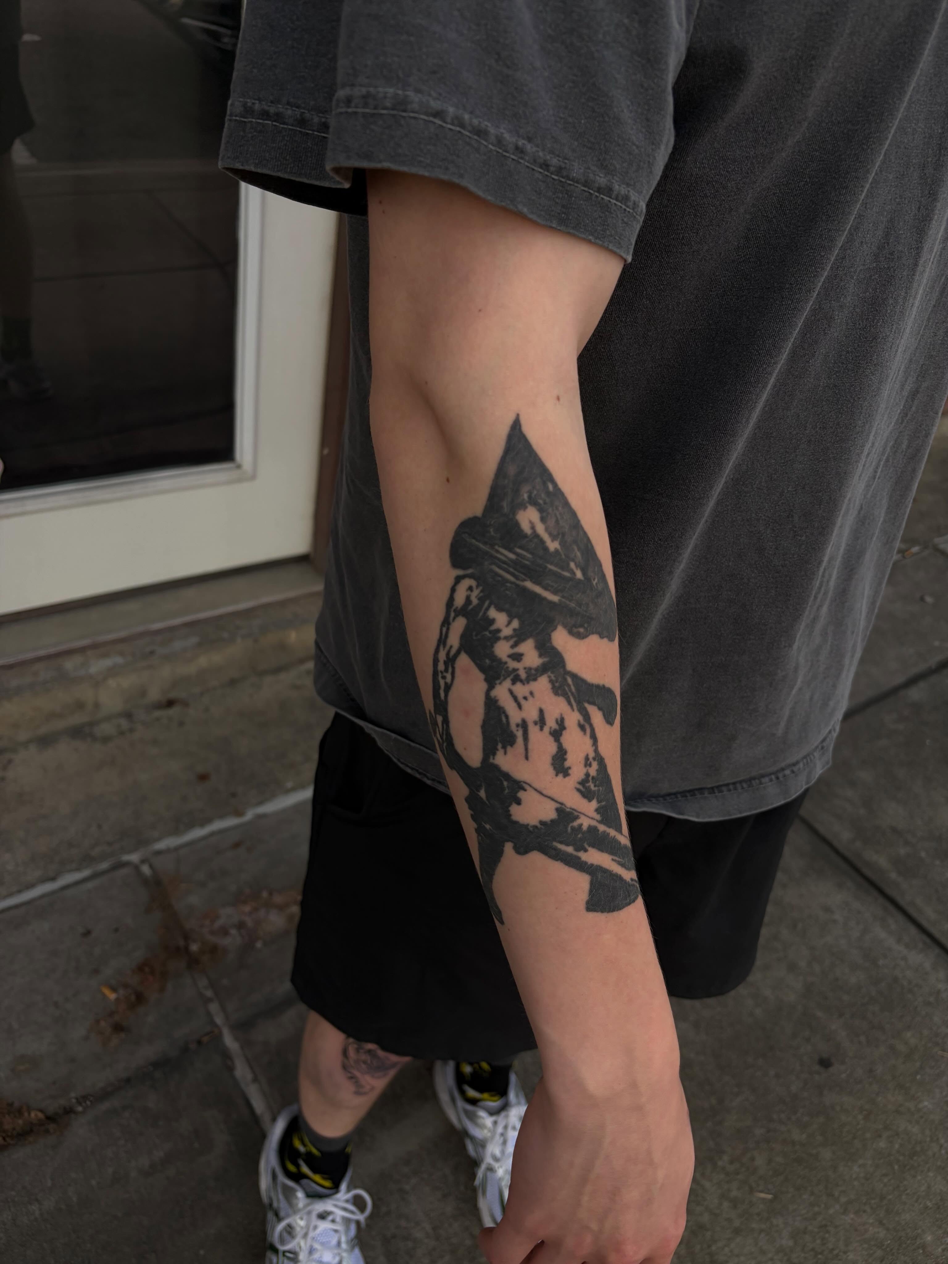 Pennywise black and grey tattoo on the forearm by neal