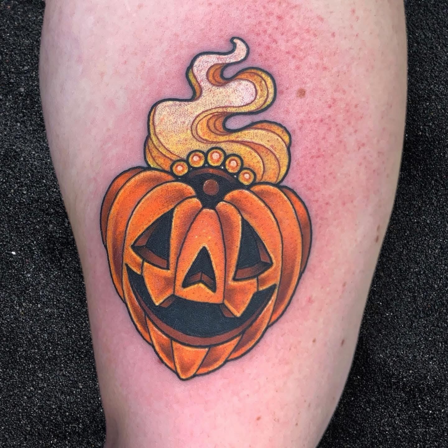 Pumpkin jack-o'-lantern American traditional tattoo on the forearm by Ash MacIsaac