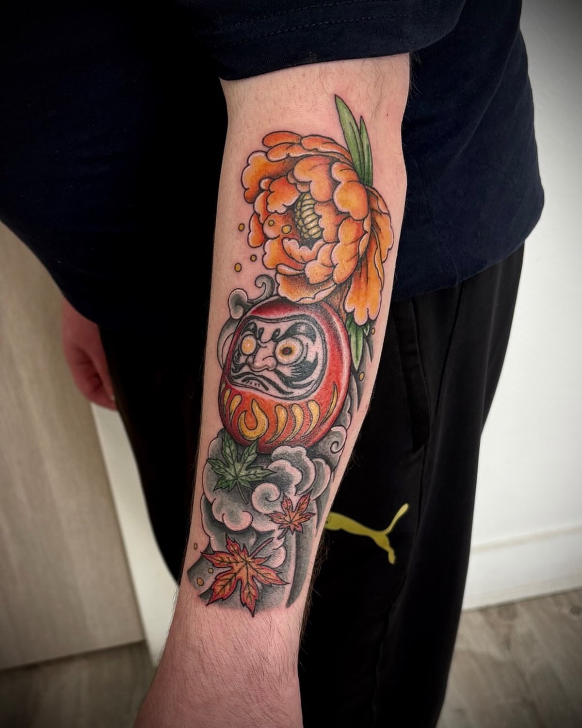 Daruma doll and flower japanese irezumi tattoo on the forearm by Deborah