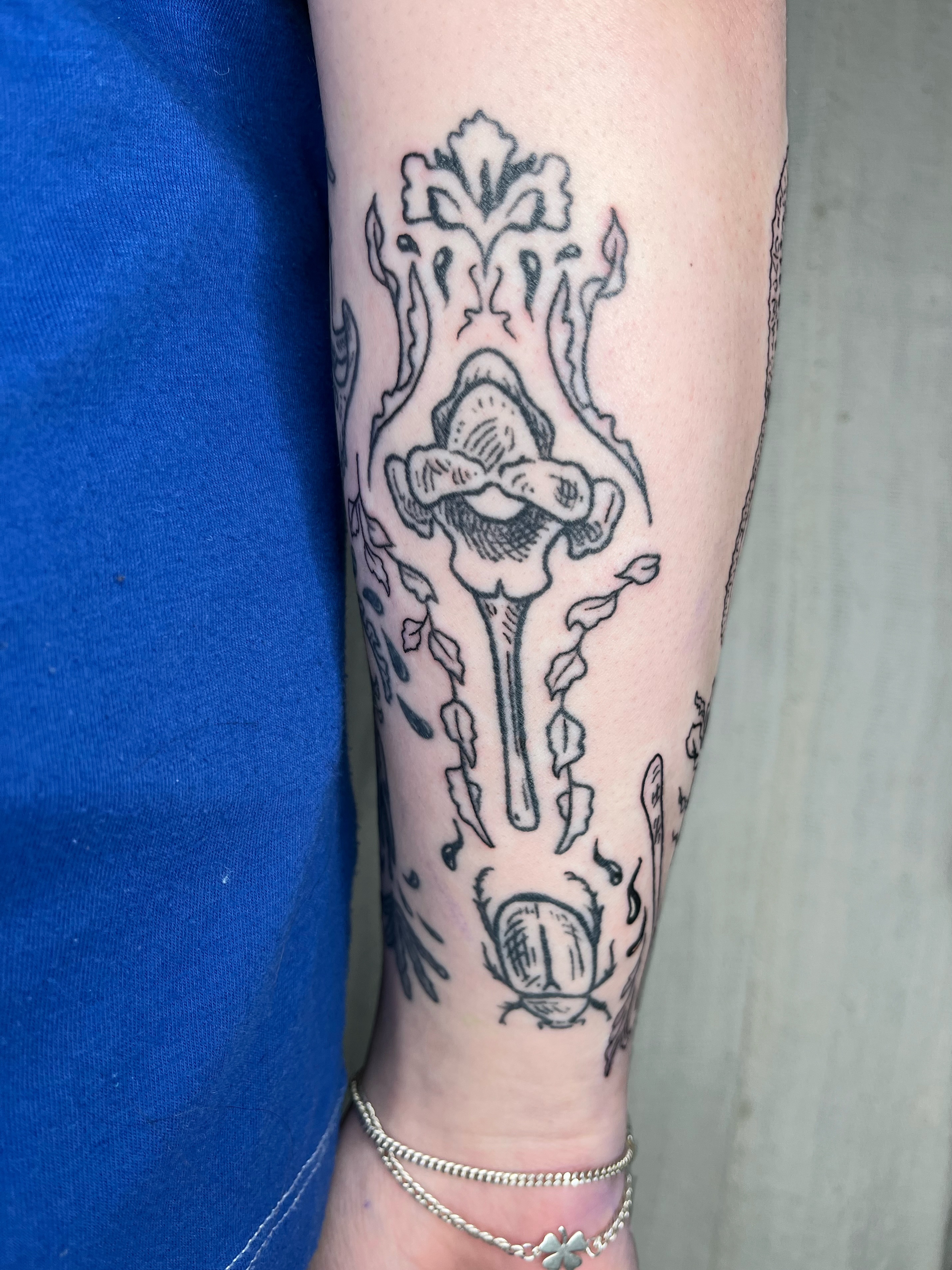 Floral arrangement black and grey tattoo on the forearm by Maris Hare, Philadelphia, Pennsylvania