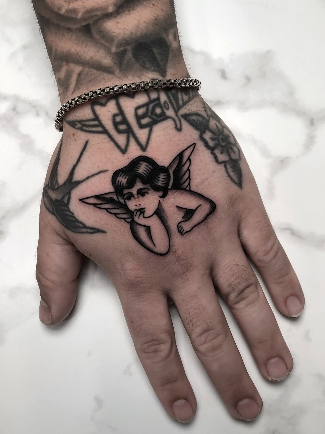 Cherub realism tattoo on the hand by Angel West