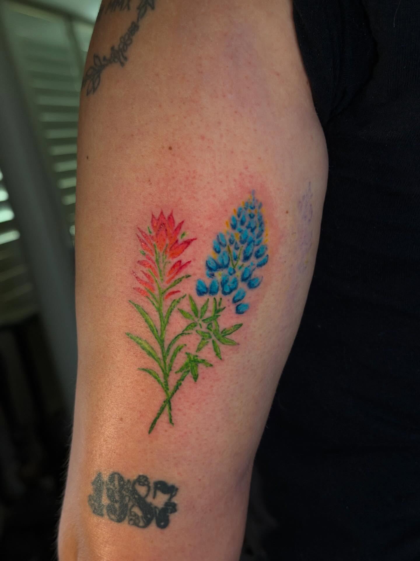 Bluebonnet and Indian paintbrush realism tattoo on the forearm by C.J.K. Roy