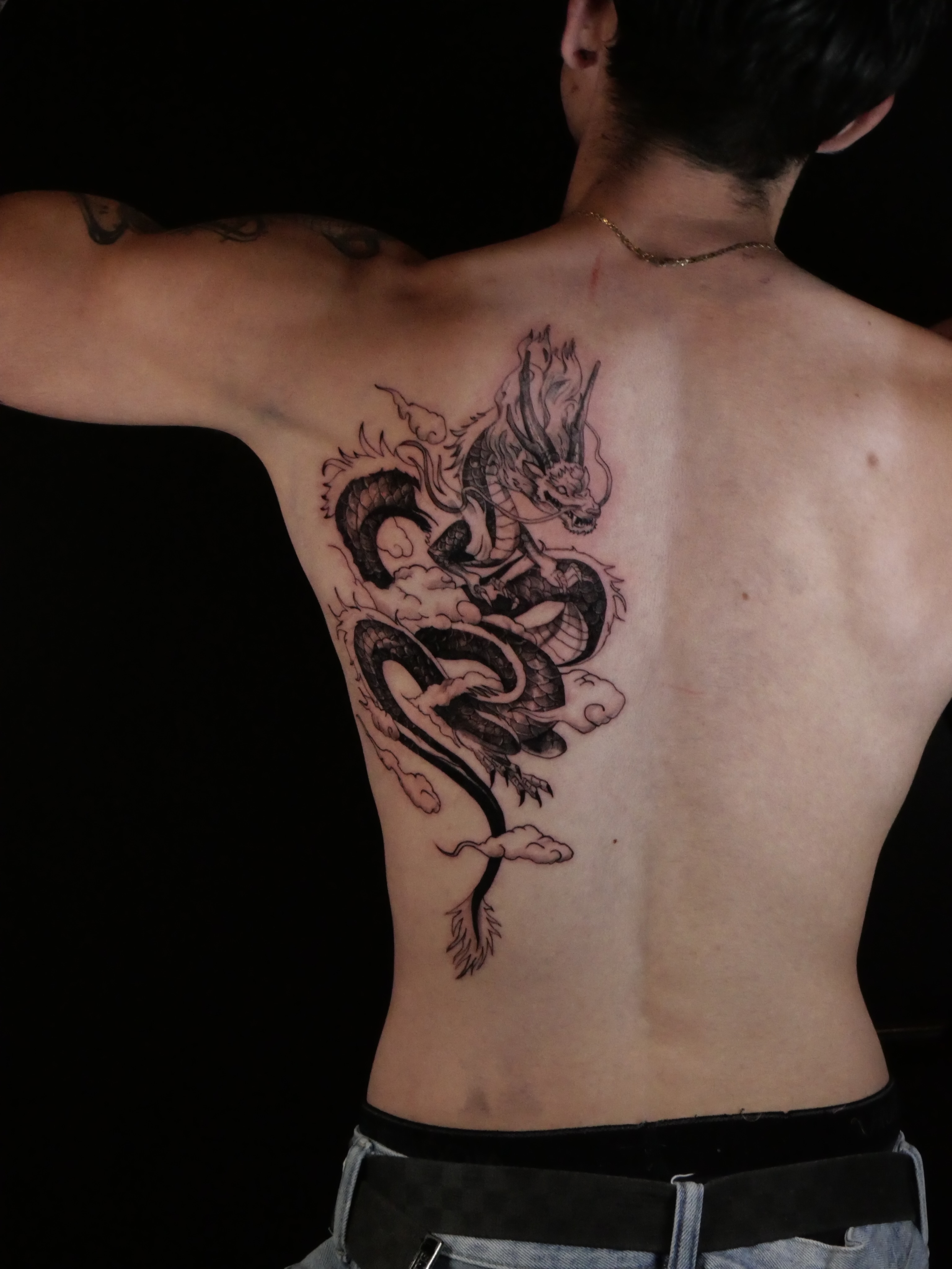 Dragon black and grey tattoo on the back by Sloppy