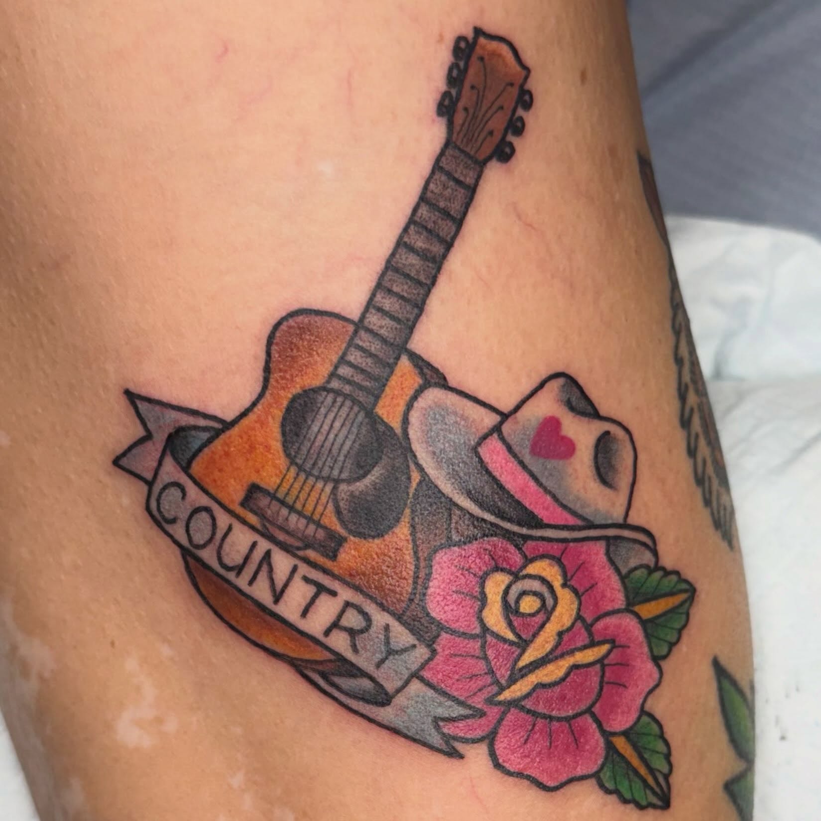 Country music American traditional tattoo on the thigh by Sue Garcia