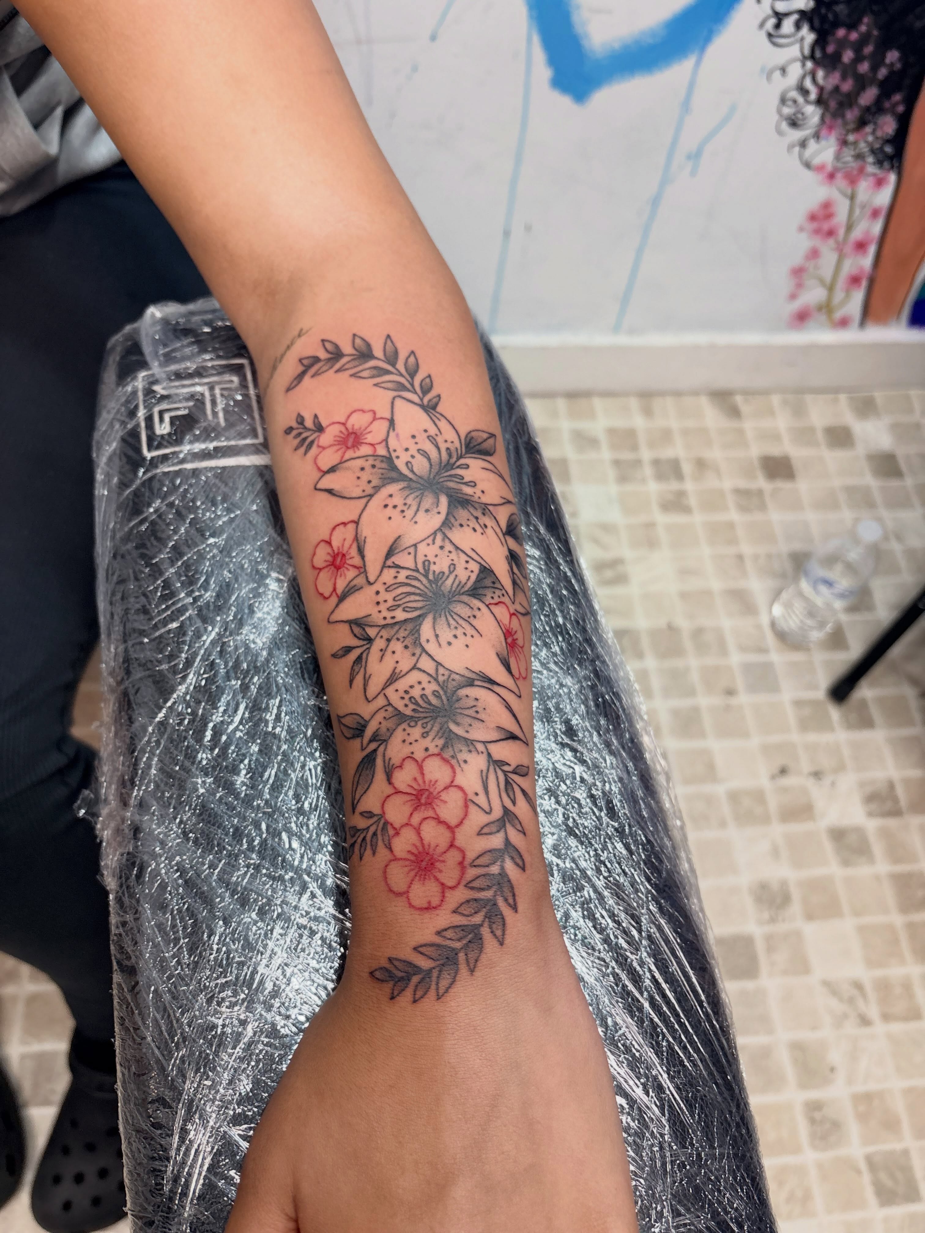 Lilies and blossoms black and grey tattoo on the forearm by 𝓚𝓪𝓻𝓶𝓪💫