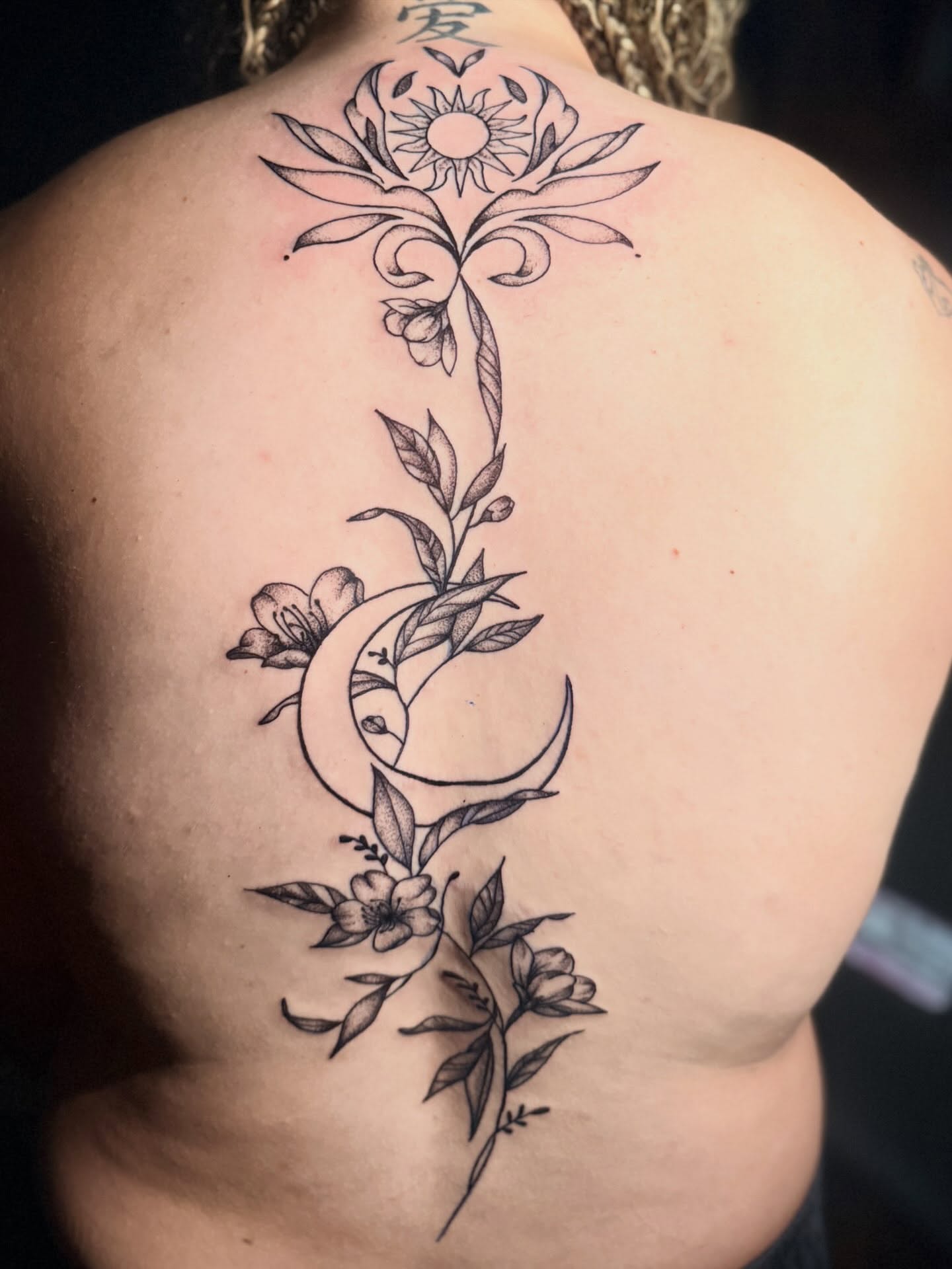 Flower and crescent moon ornamental tattoo on the back by Alesia