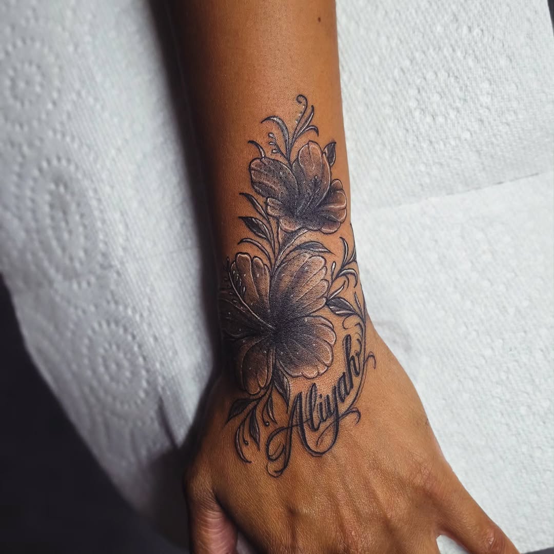Hibiscus flowers and name fine line tattoo on the forearm by Kai_Tattoo