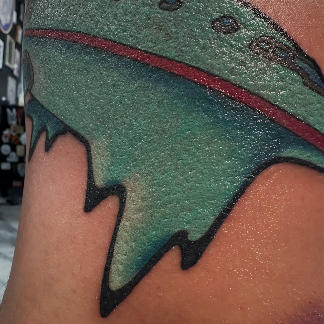 Abstract shape with red stripe tattoo on the upper arm by Chad Phillips