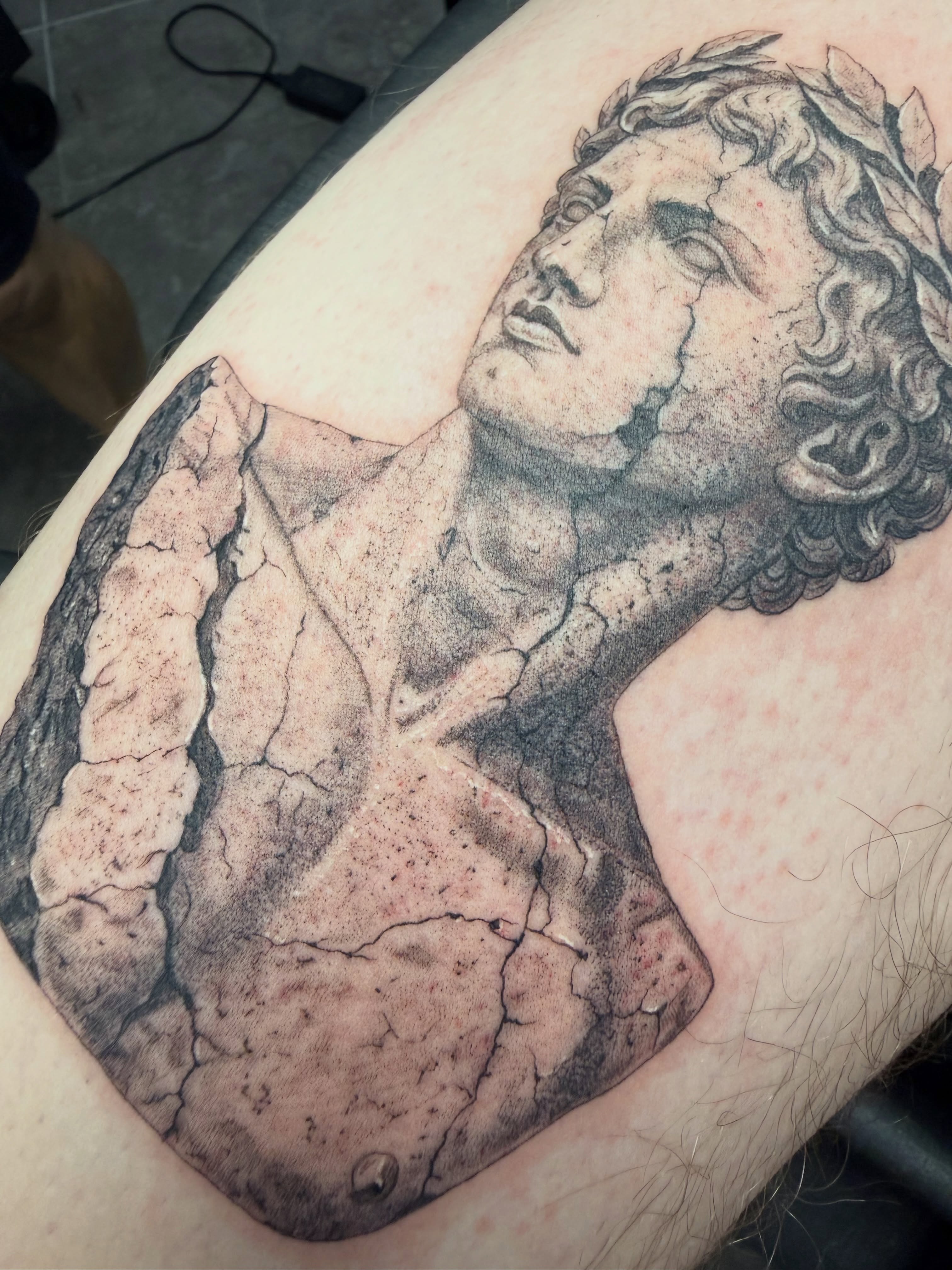 Statue bust black and grey tattoo on the thigh by Juan Guzman