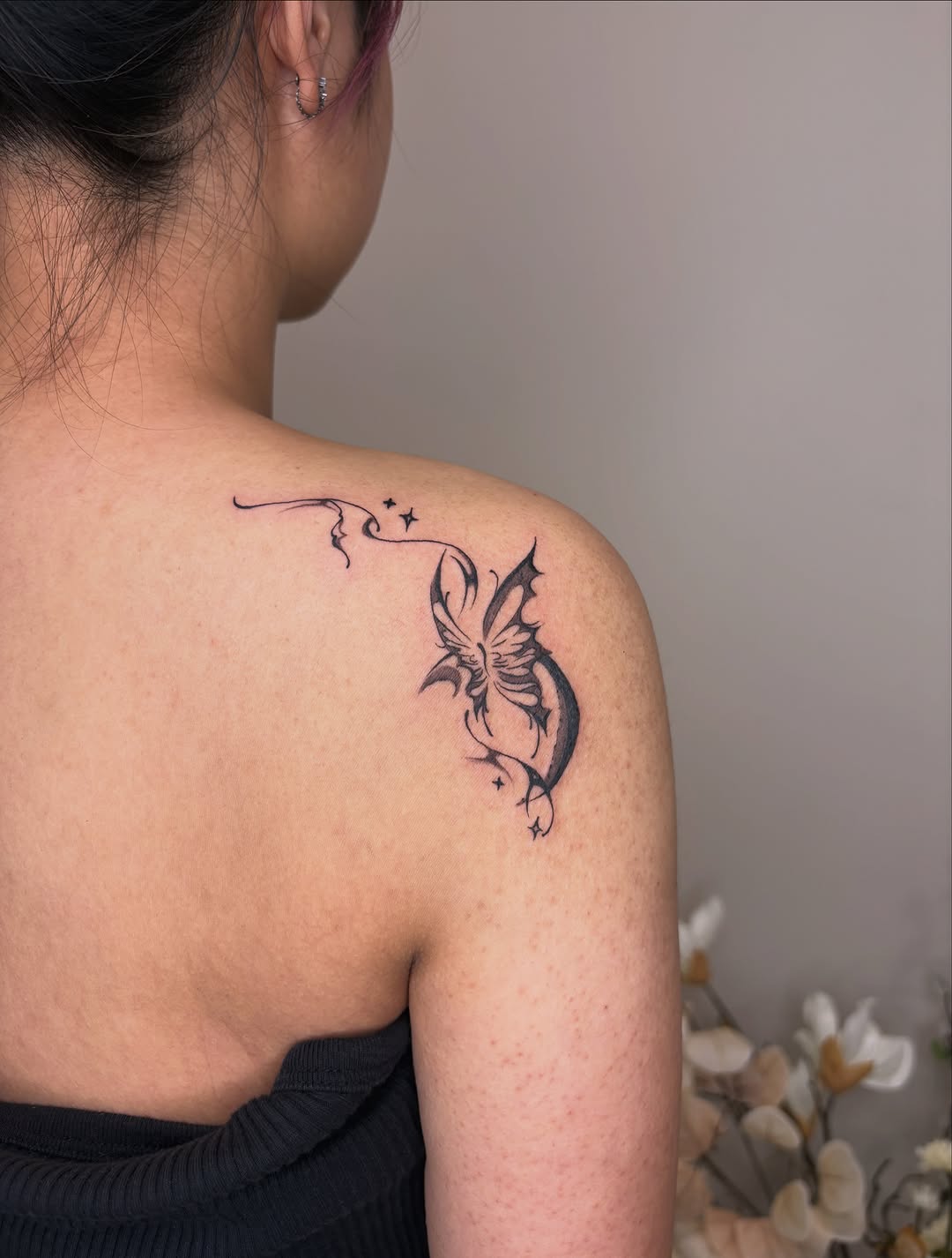 Butterfly with swirling lines and stars blackwork tattoo on the shoulder by *:・kelly✧*:・゚