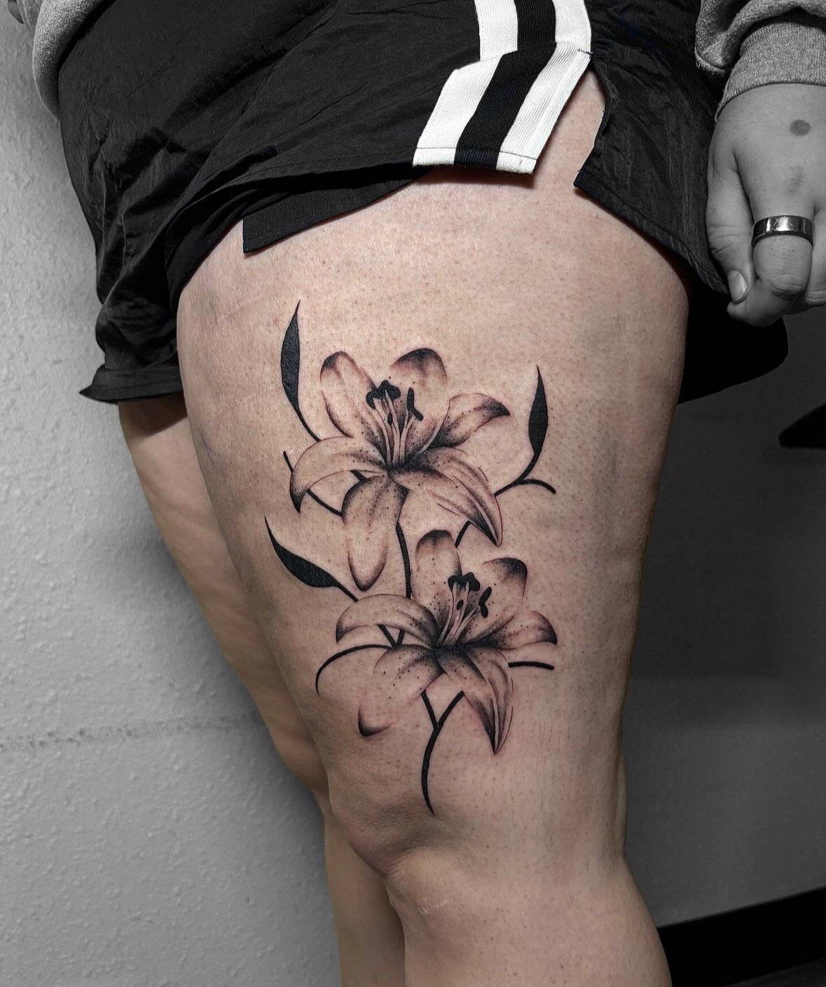 Lilies black and grey tattoo on the thigh by Grace L